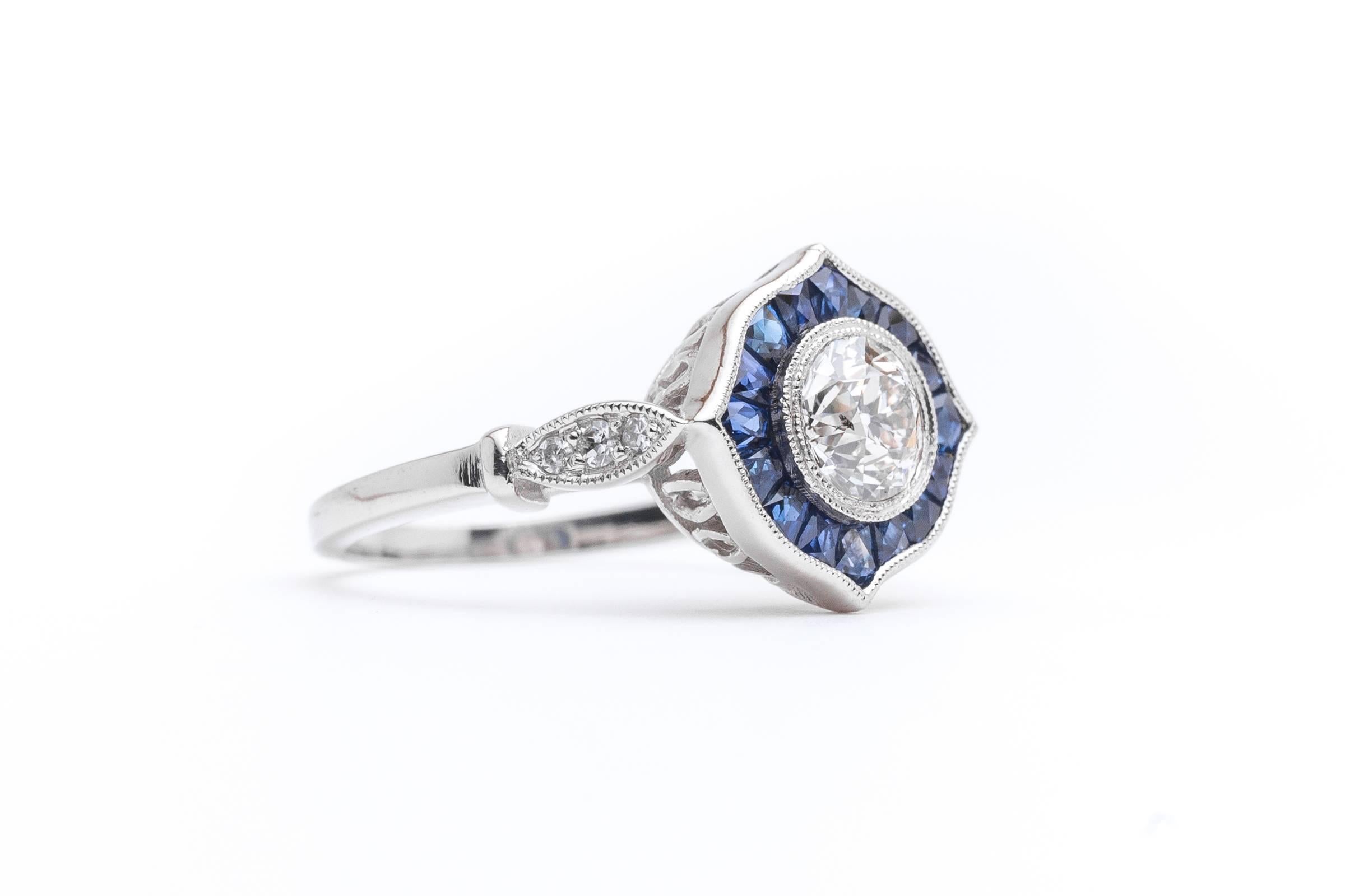 A truly incredible diamond and sapphire ring set in luxurious platinum. Centering this fantastic ring is a beautiful diamond of 0.86 carats surrounded by French cut sapphires.  

The center diamond is a beautiful VS clarity and F/G color antique