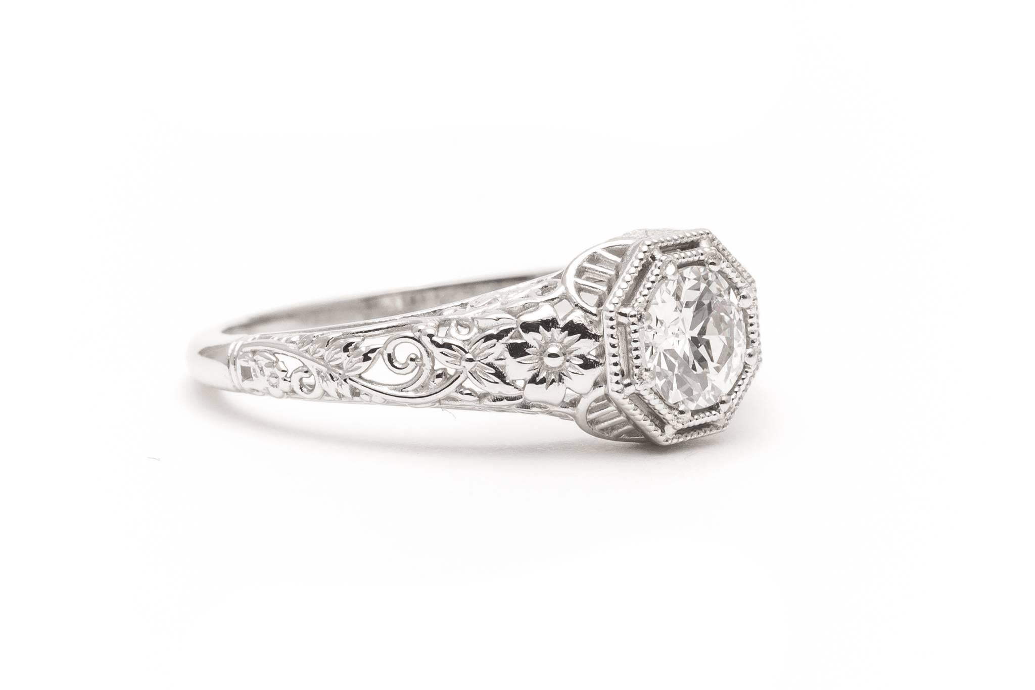 A stunning floral motif filigree ring in luxurious platinum.  Centered by a 0.52 carat antique European cut diamond this ring features exceptionally fine quality hand pierced filigree work and hand carved flowers throughout.

Grading as beautiful VS