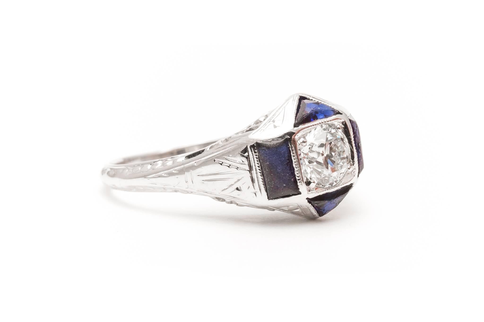 An original art deco period diamond and sapphire engagement ring in 18 karat white gold. Centered by a high quality 0.55 carat antique European cut diamond this ring features four accenting sapphires and a fantastic filigree mounting.

Grading as