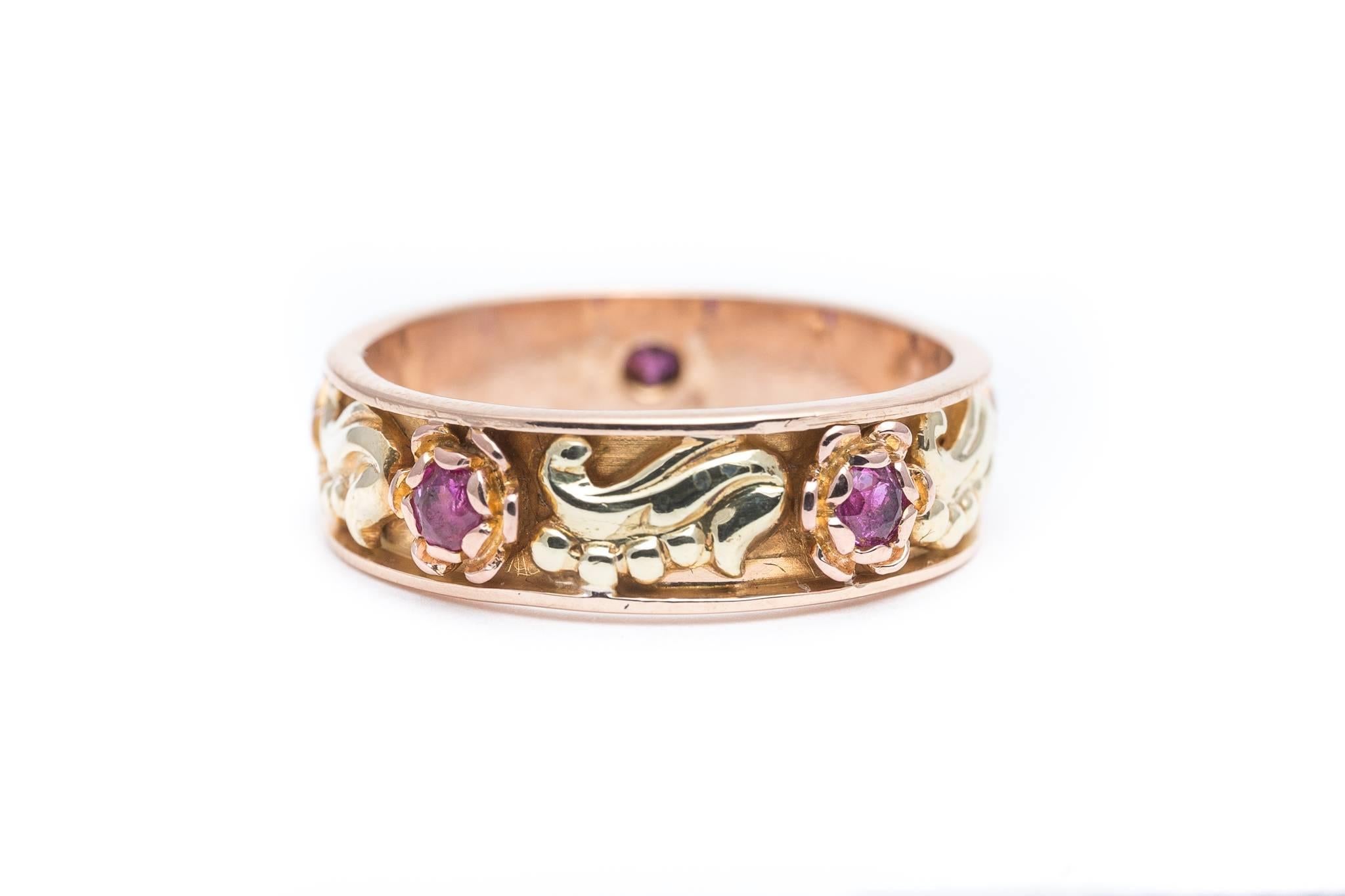 A beautiful original vintage retro period ruby wedding band in yellow, and rose gold.  Featuring a total of five vintage European cut rubies set in the center of beautifully detailed rose gold flowers this ring features yellow gold leaves in-between