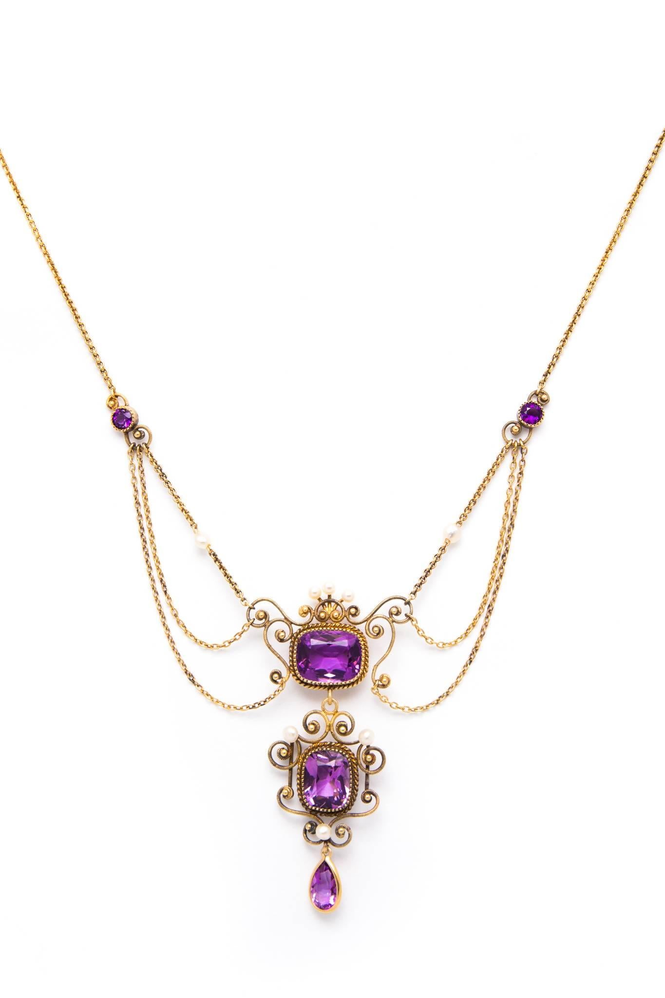 An original edwardian period amethyst and pearl festoon style necklace in 14 karat yellow gold.  Boasting a trio of rich vividly colored amethyst this necklace is set throughout with glistening top quality pearls.

Weighing approximately fourteen