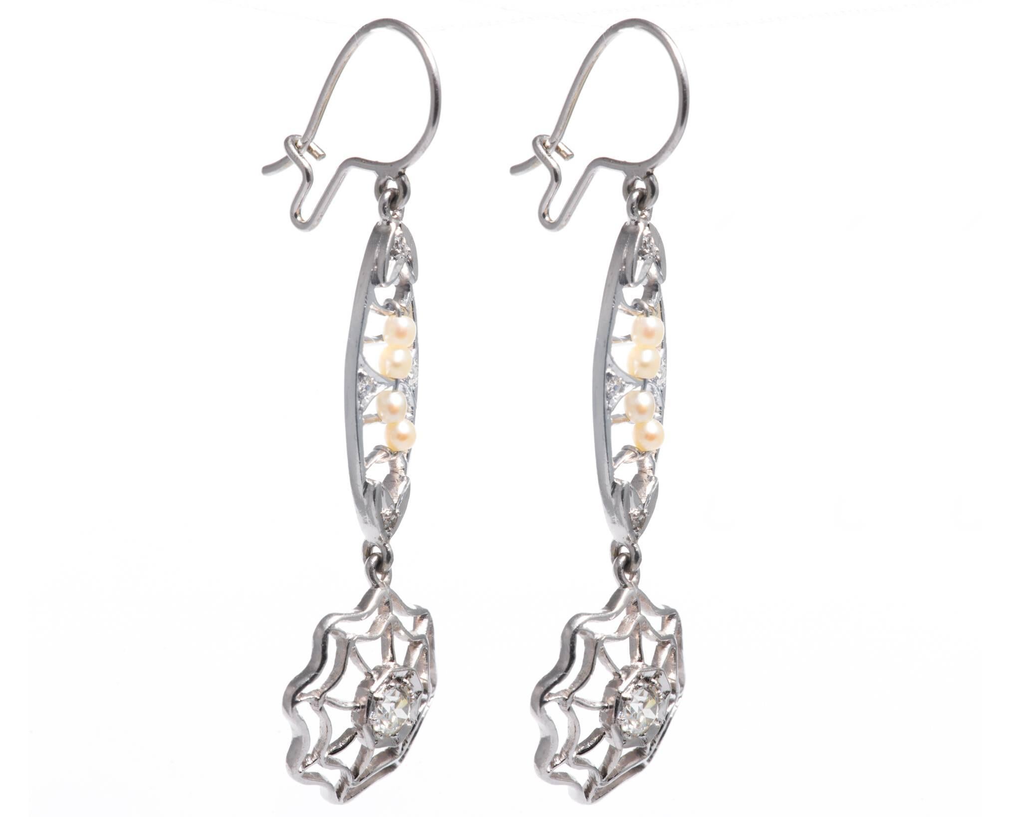 A pair of art deco period dreamcatcher style earrings in platinum. Set with sparkling diamonds and natural pearls these earrings feature beautiful handmade wire filigree work throughout.

Crafted as a pair of dreamcatchesrs, these wire backing