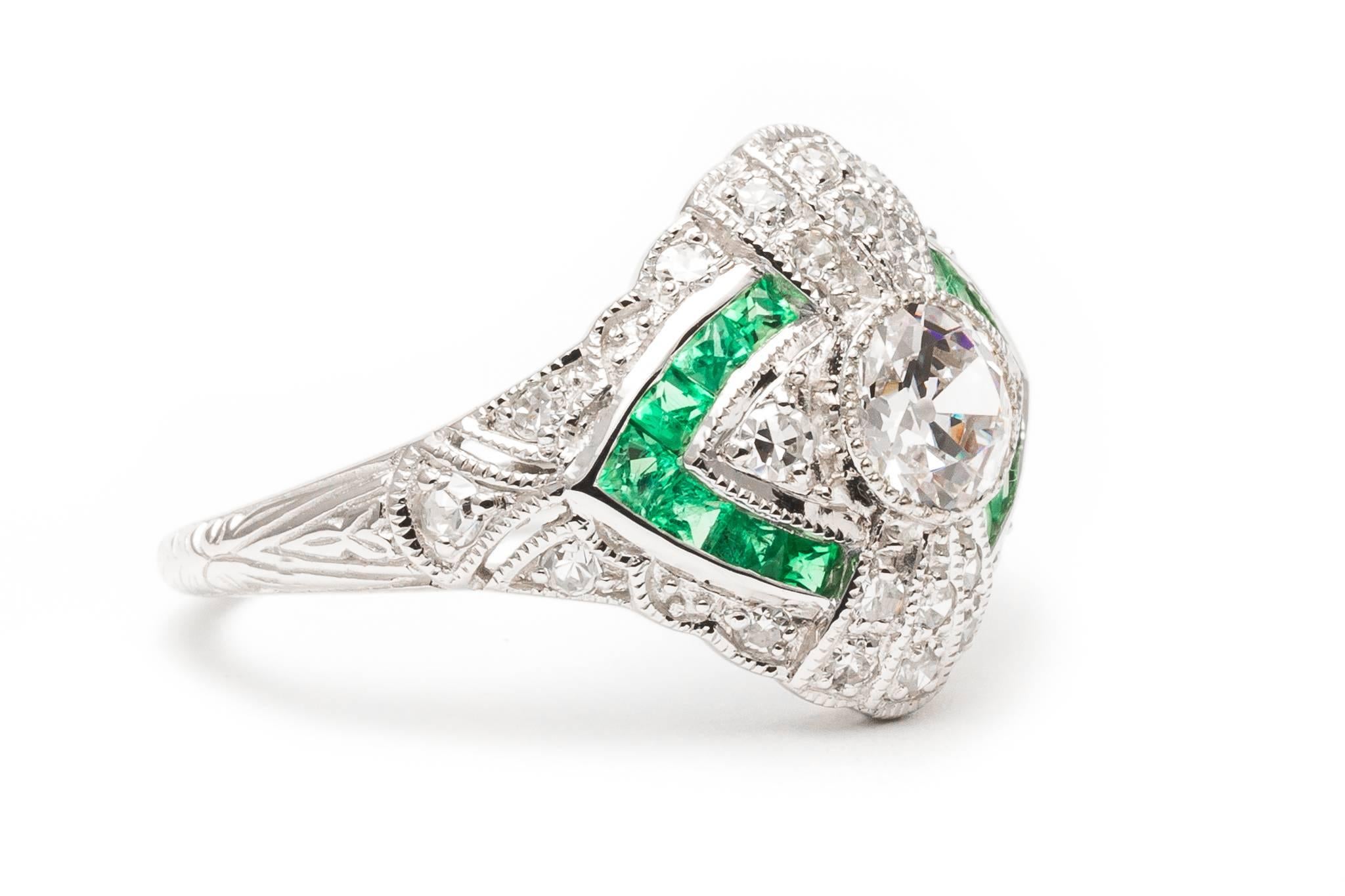 A beautiful and very vibrant French cut emerald, and antique cut Diamond ring.  Featuring a European cut diamond center framed by pave set diamond rays and French cut emeralds.

Grading as superb VS clarity and G colorless color, the center is a