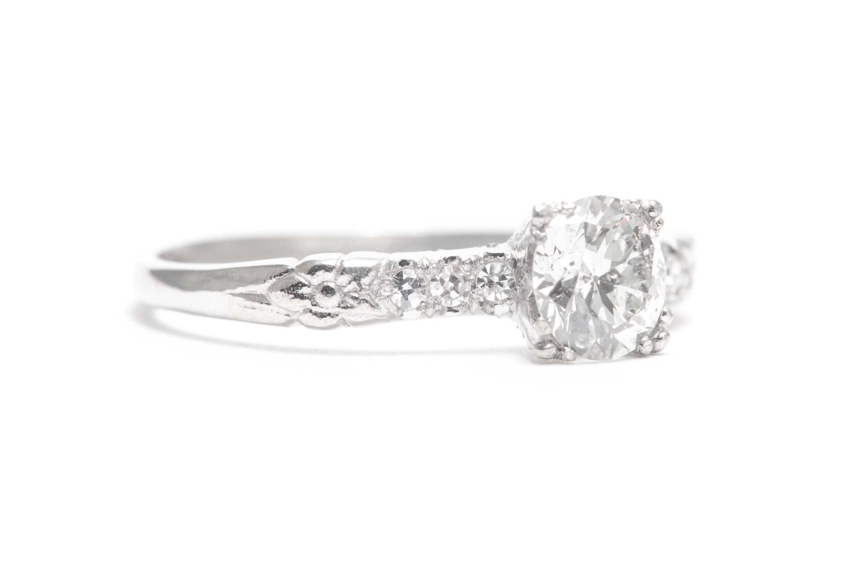 A beautiful original art deco period diamond engagement ring in luxurious platinum.  Featuring a sparkling antique European cut diamond accented by petit Swiss cut diamonds, this ring also features hand carved orange blossom flowers.

Weighing 0.70