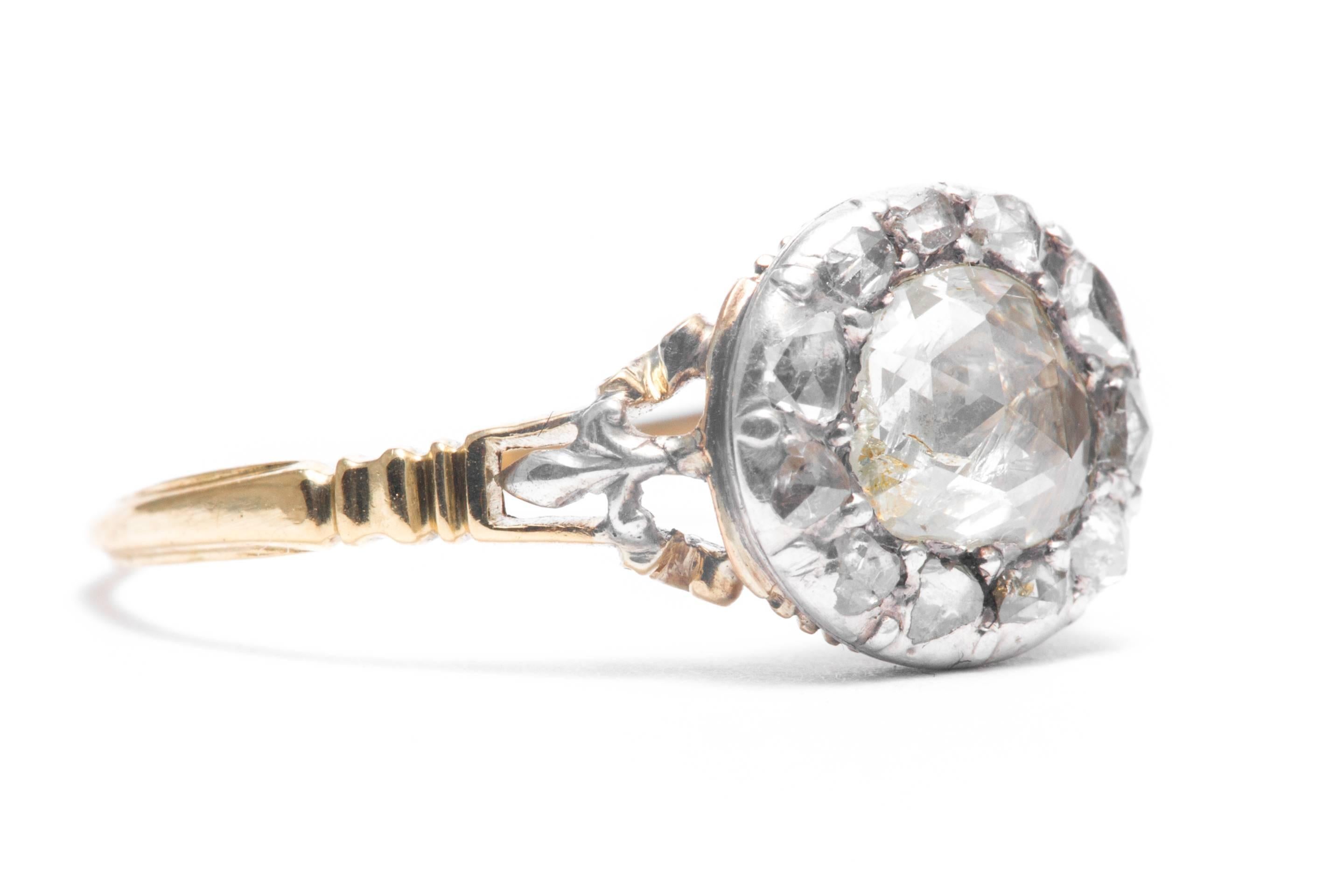 An original 18th century period Georgian, rose cut diamond engagement ring in 18 karat yellow gold and silver.  In remarkable and original condition, this ring features a central rose cut diamond framed by smaller rose cut diamonds set in silver