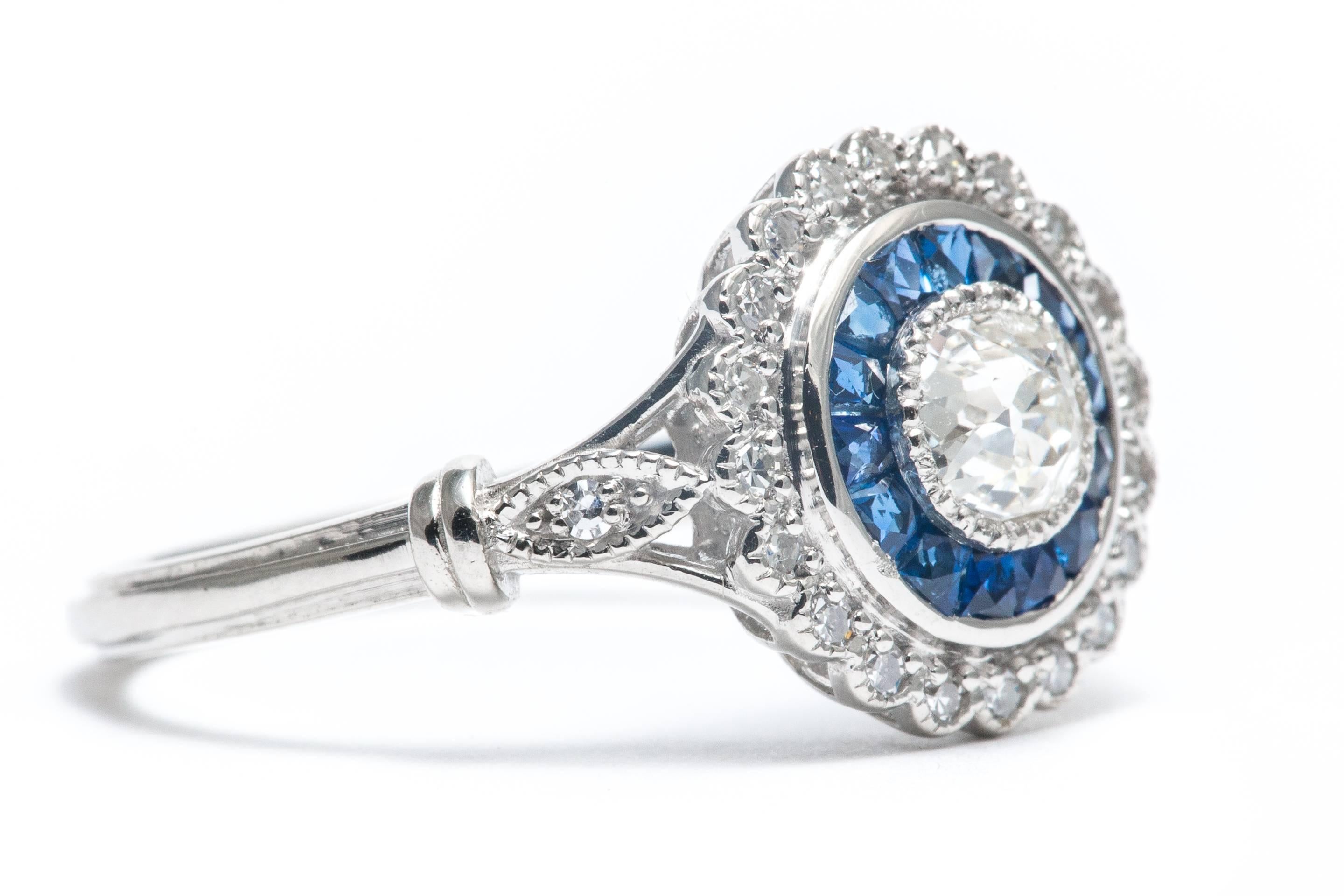 A beautiful handmade double halo style European cut diamond and French cut sapphire diamond engagement ring set in luxurious platinum.  Centered by a beautiful European cut diamond, this ring features a halo of French cut sapphires followed by yet