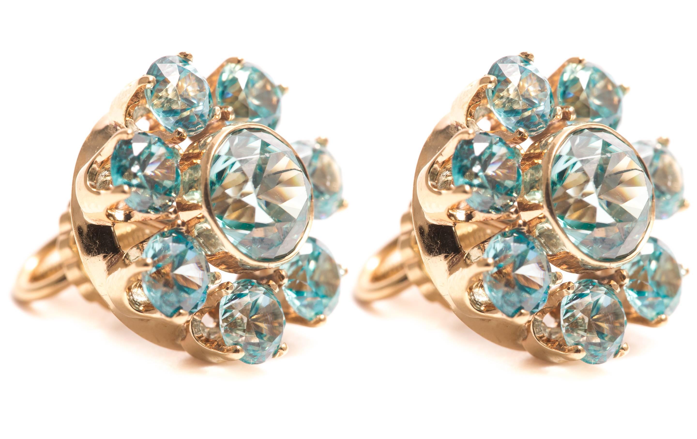 Beacon Hill Jewelers Presents:

A beautiful pair of blue zircon halo form earrings in 14 karat yellow gold.  Centered by a bezel set European cut blue zircon these earrings feature halos of seven prong set zircons.  Grading as beautiful VS clarity