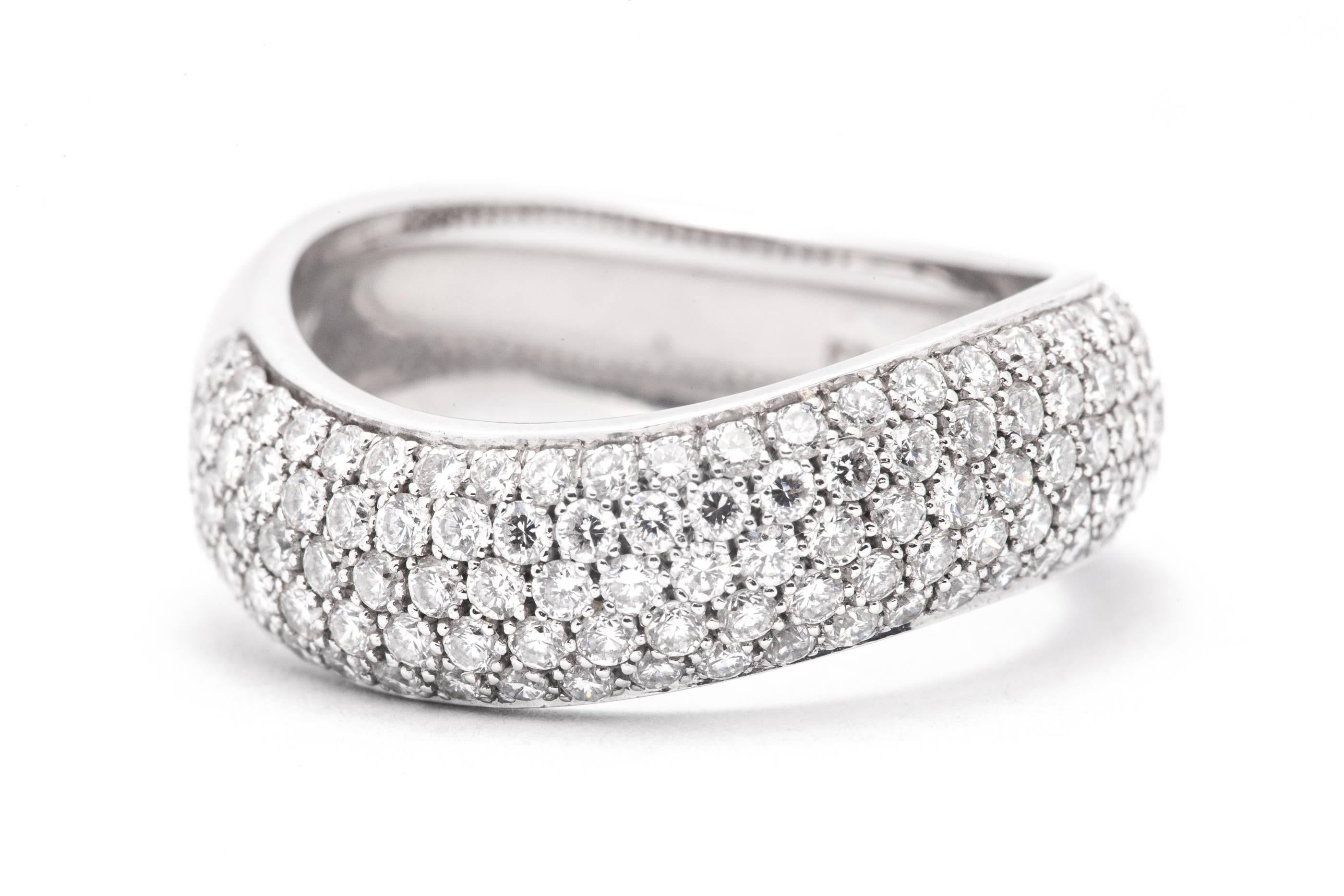 A wave shaped diamond ring in 18 karat white gold.  Pave set with a total of one hundred twenty nine brilliant cut diamonds, this ring provides incredible sparkle and beauty.  

All grading as superb VS clarity, and G color the diamonds are all
