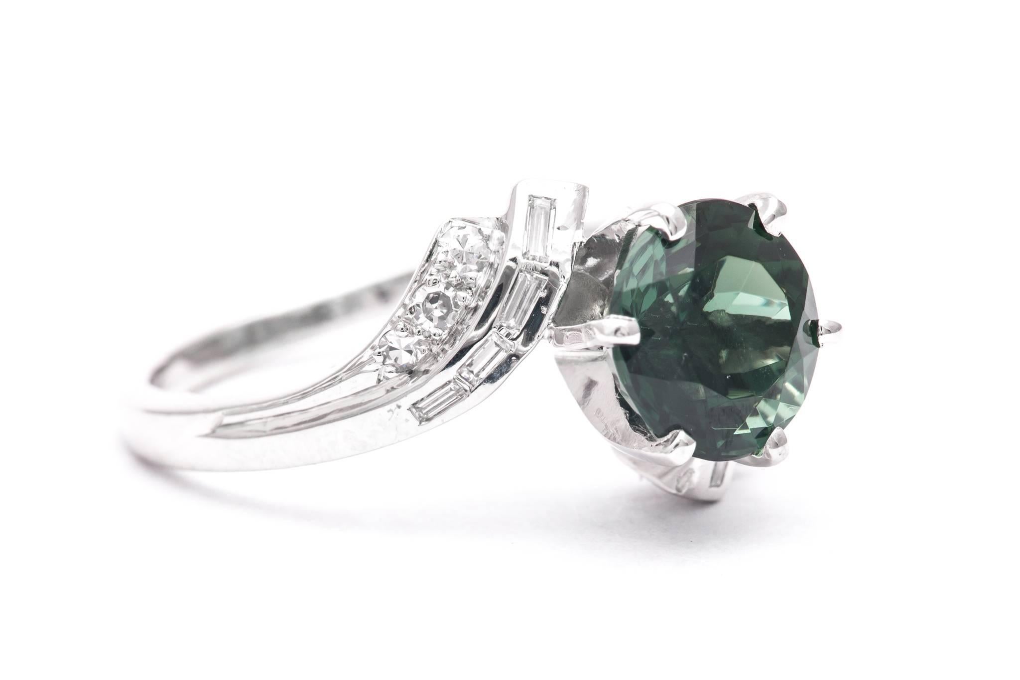 A mid century retro style tourmaline, and diamond ring set in luxurious platinum.  Centered by a beautiful gem quality 2.60 carat European cut tourmaline this ring features accenting baguette and Swiss cut diamonds in platinum.

Grading as beautiful