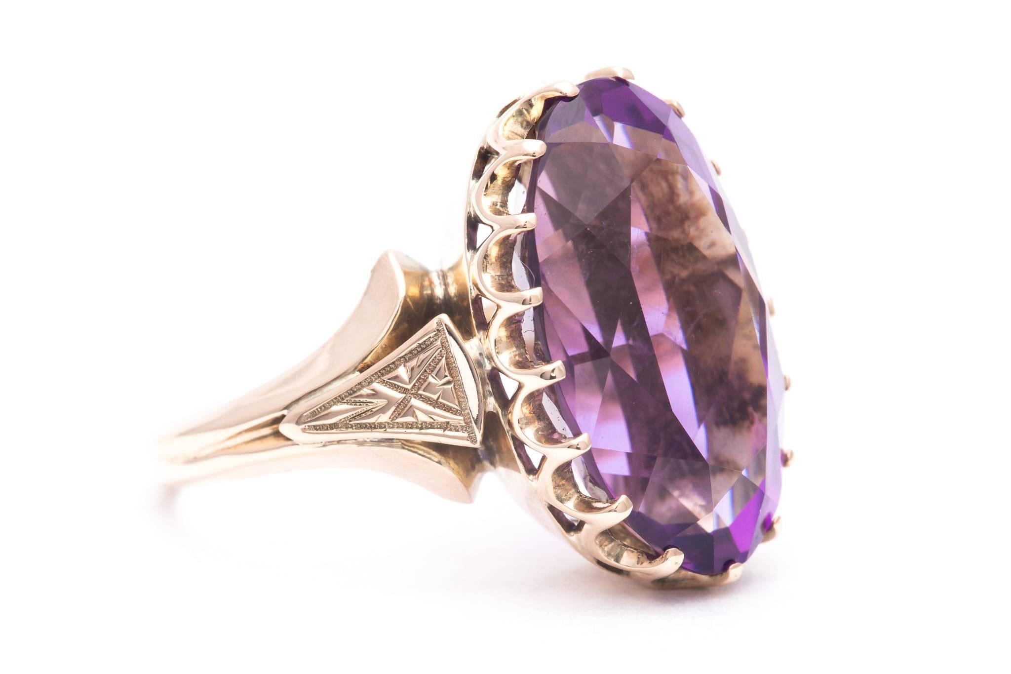 An original victorian period amethyst solitaire ring in 14 karat yellow gold.  Featuring a hand crafted crown like mounting with hand engraving on the shoulders; this ring is set with a single large oval cut amethyst solitaire.

Weighing 9.50 carats