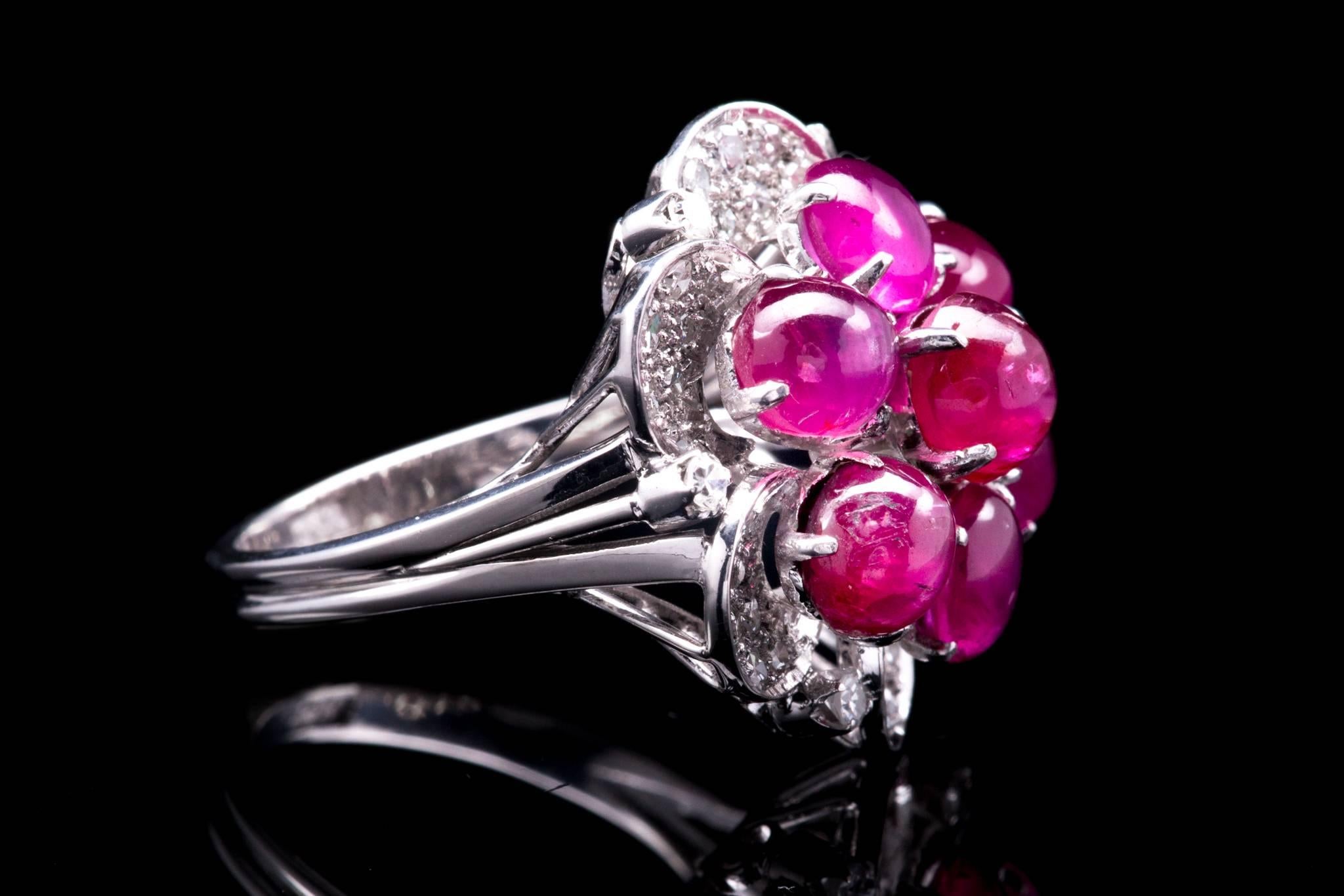 A beautiful mid century ruby, and diamond flower shape ring in luxurious platinum.  Pave set with a background of dazzling diamonds this ring features seven bright richly colored cabochon rubies set in platinum.

Weighing approximately 9 carats