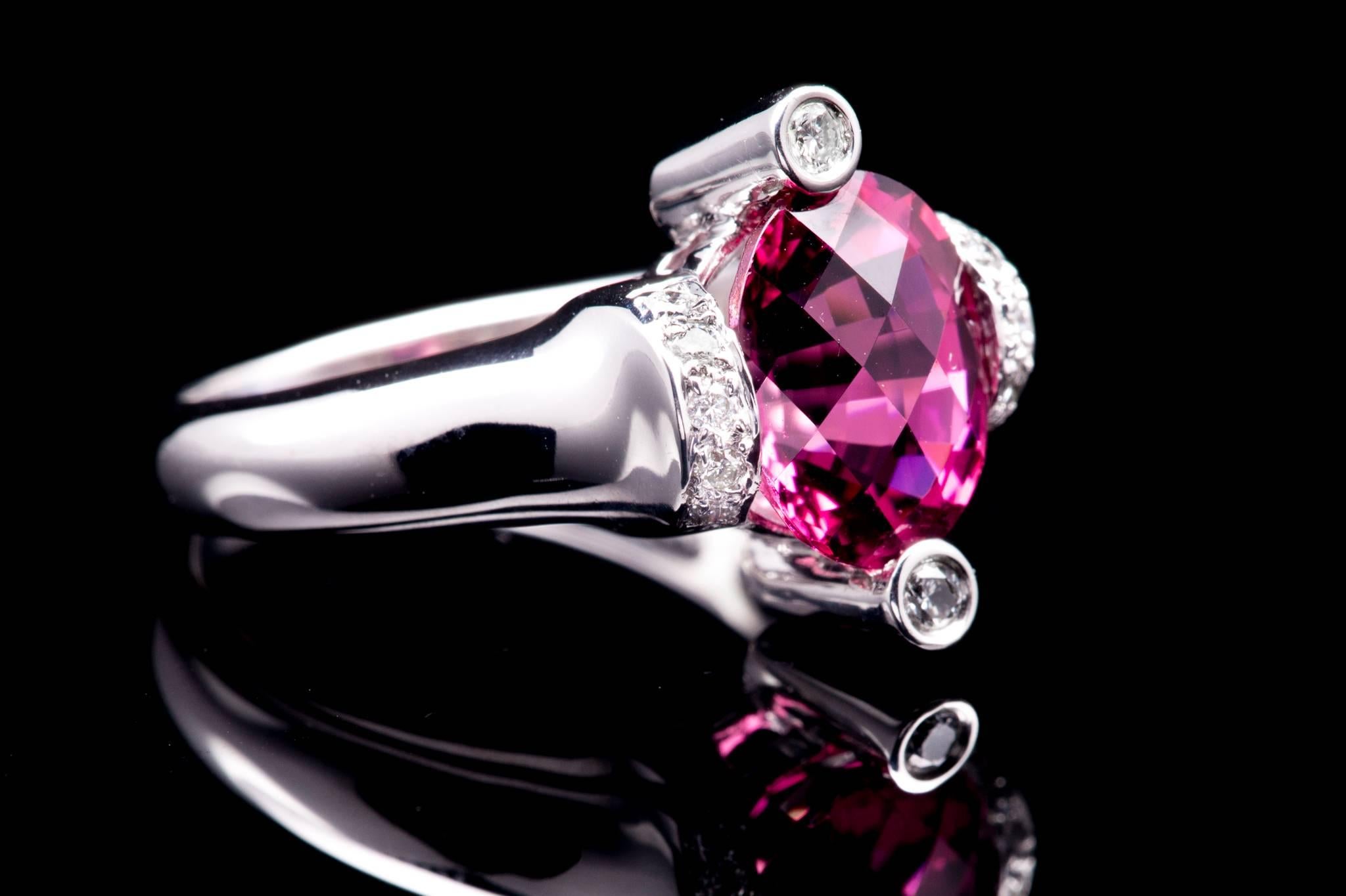 A contemporary rubellite tourmaline and diamond ring in 14 karat white gold.  Accented by a dozen bezel and pave set diamonds this ring features a nearly 4 carat cushion shaped tourmaline in a unique and hand crafted mounting.

Grading as beautiful