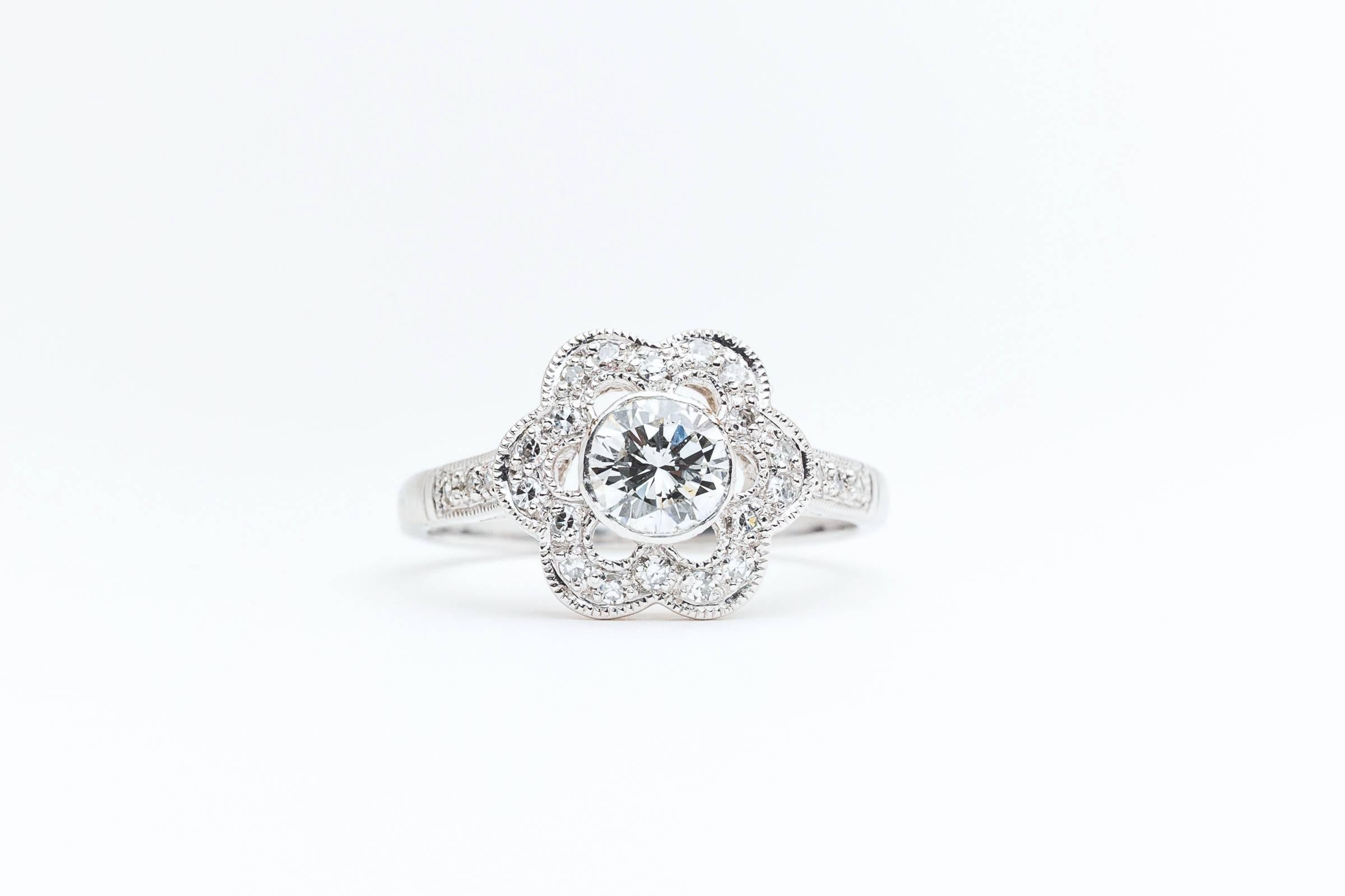 A beautiful flower form platinum and diamond engagement ring. Centered by a bezel set round brilliant cut 0.58 carat diamond, this beautiful flower features hand formed diamond studded petals.

Set in a brightly polished bezel of luxurious 900 fine