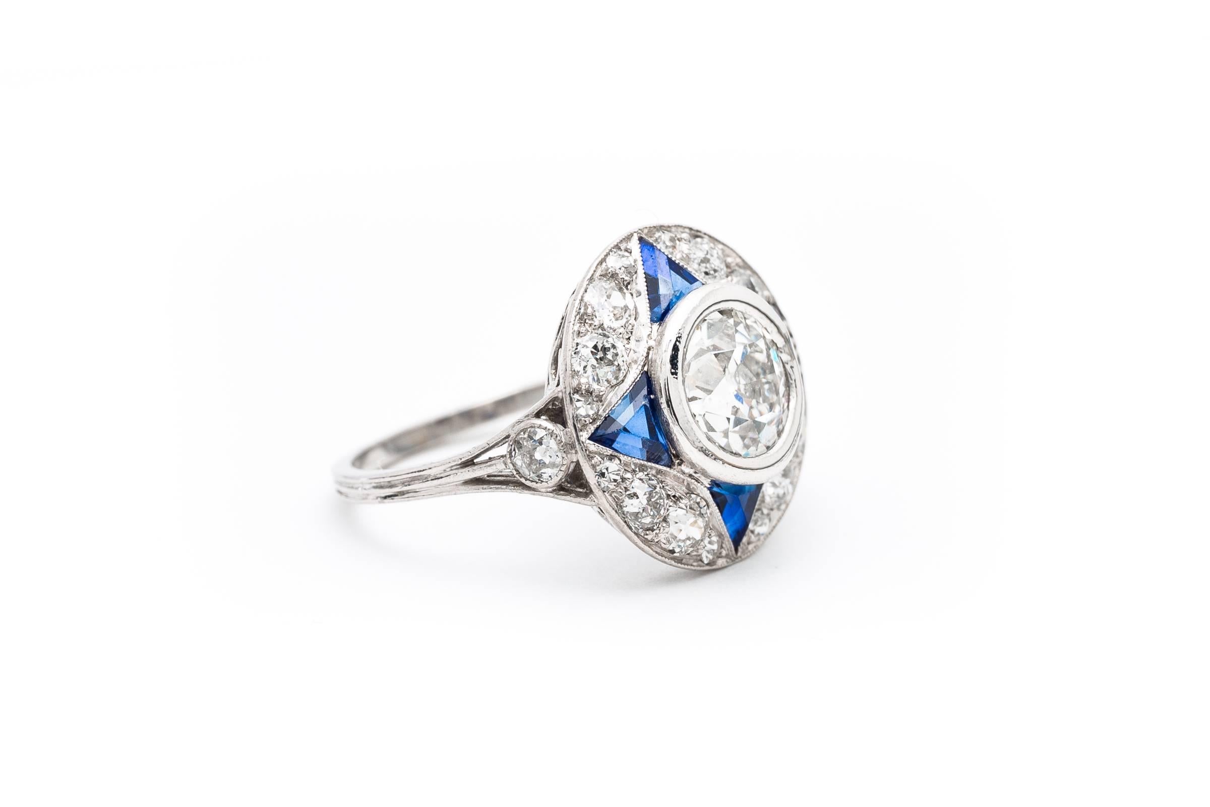 A stunning art deco period diamond and sapphire engagement ring in platinum. Centered by a gorgeous 1.18 carat old european cut center diamond, this ring features accenting French cut sapphires in a spectacular hand crafted platinum