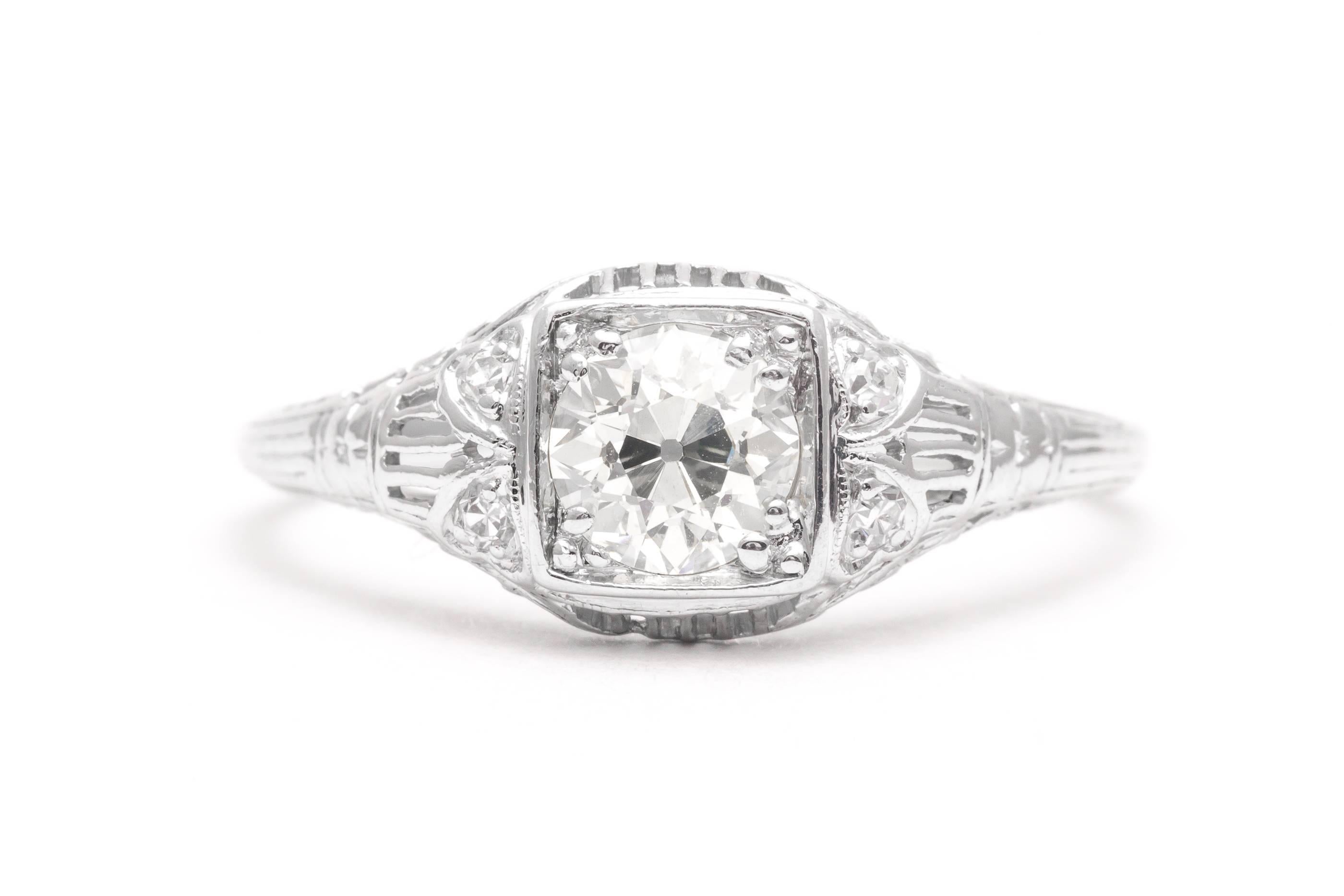 A beautiful art deco period diamond engagement ring in luxurious platinum. Centered by a high quality 0.90 carat old European cut diamond this ring features beautiful hand pierced filigree work along with sparkling accenting diamonds.

Grading as