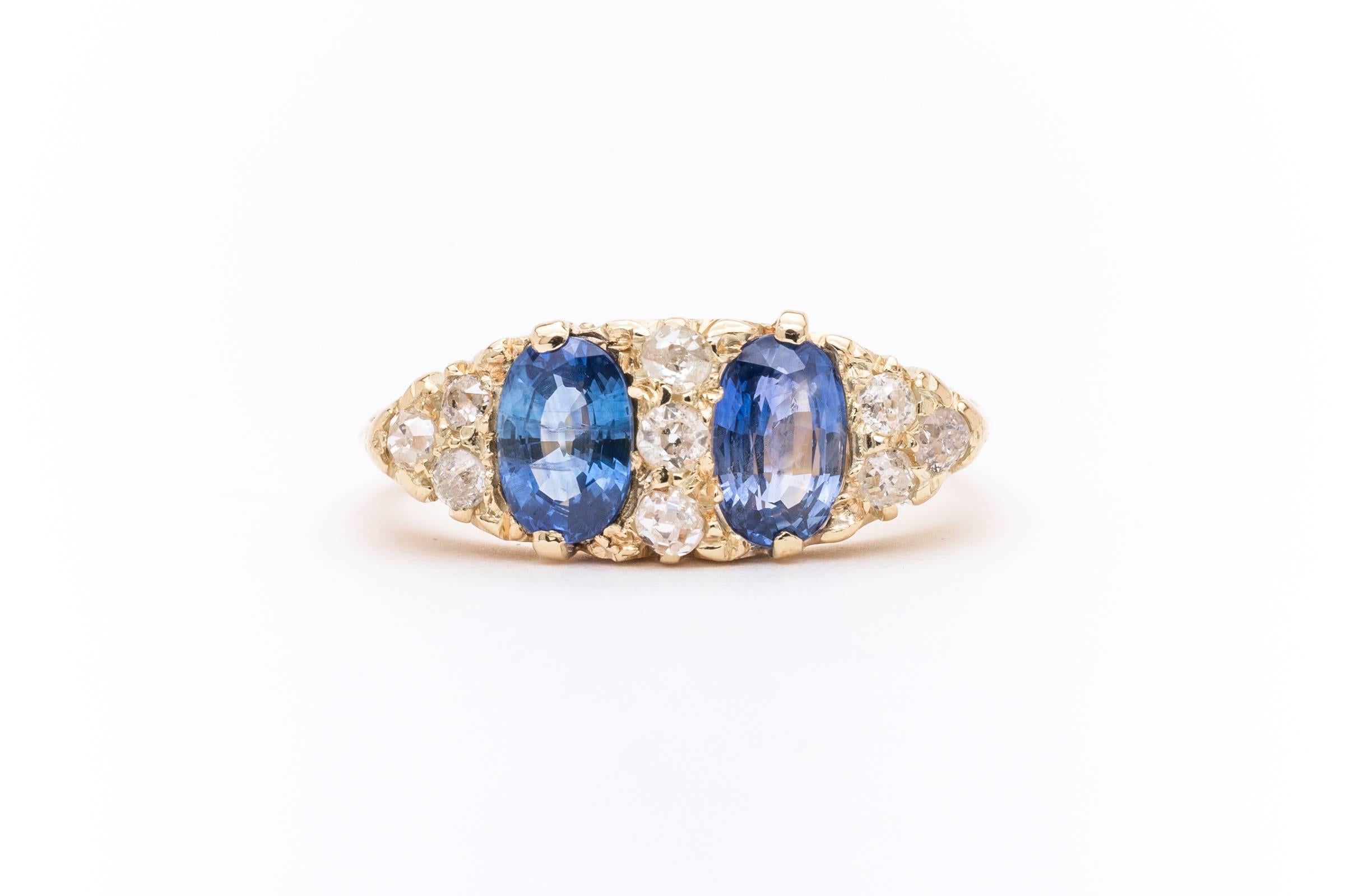 Beacon Hill Jewelers Presents:

A beautiful English victorian period sapphire and diamond ring in luxurious 18 karat yellow gold. Centered by a pair of beautiful elongated shaped cornflower blue Ceylon sapphires, this ring features beautiful