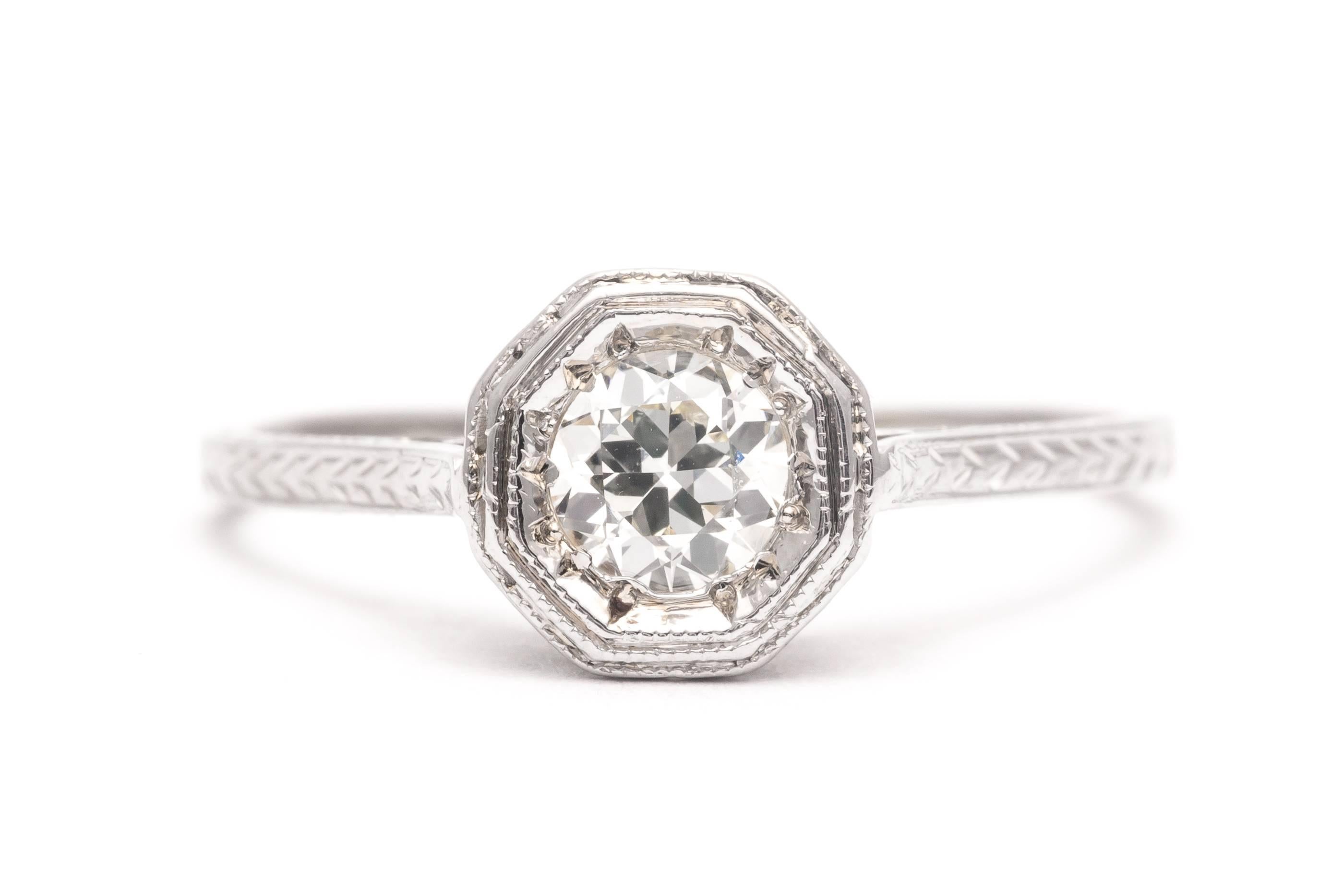 Beacon Hill Jewelers Presents:

A beautiful art deco period diamond solitaire engagement ring in 14 karat white gold. Set with a single old European cut diamond this ring features beautiful hand wrought filigree work on the north and south sides