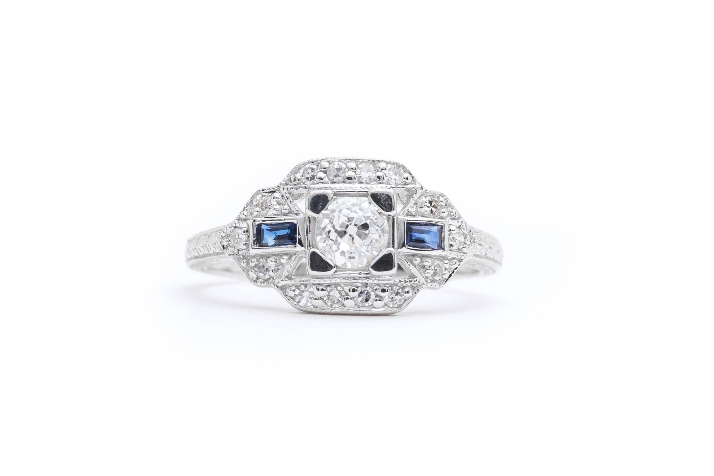 Beacon Hill Jewelers presents:

A beautiful hand engraved diamond and sapphire ring in 14 karat white gold. Centered by a sparkling antique old European cut diamond of 0.42 carats this ring features antique single cut diamonds set throughout, as