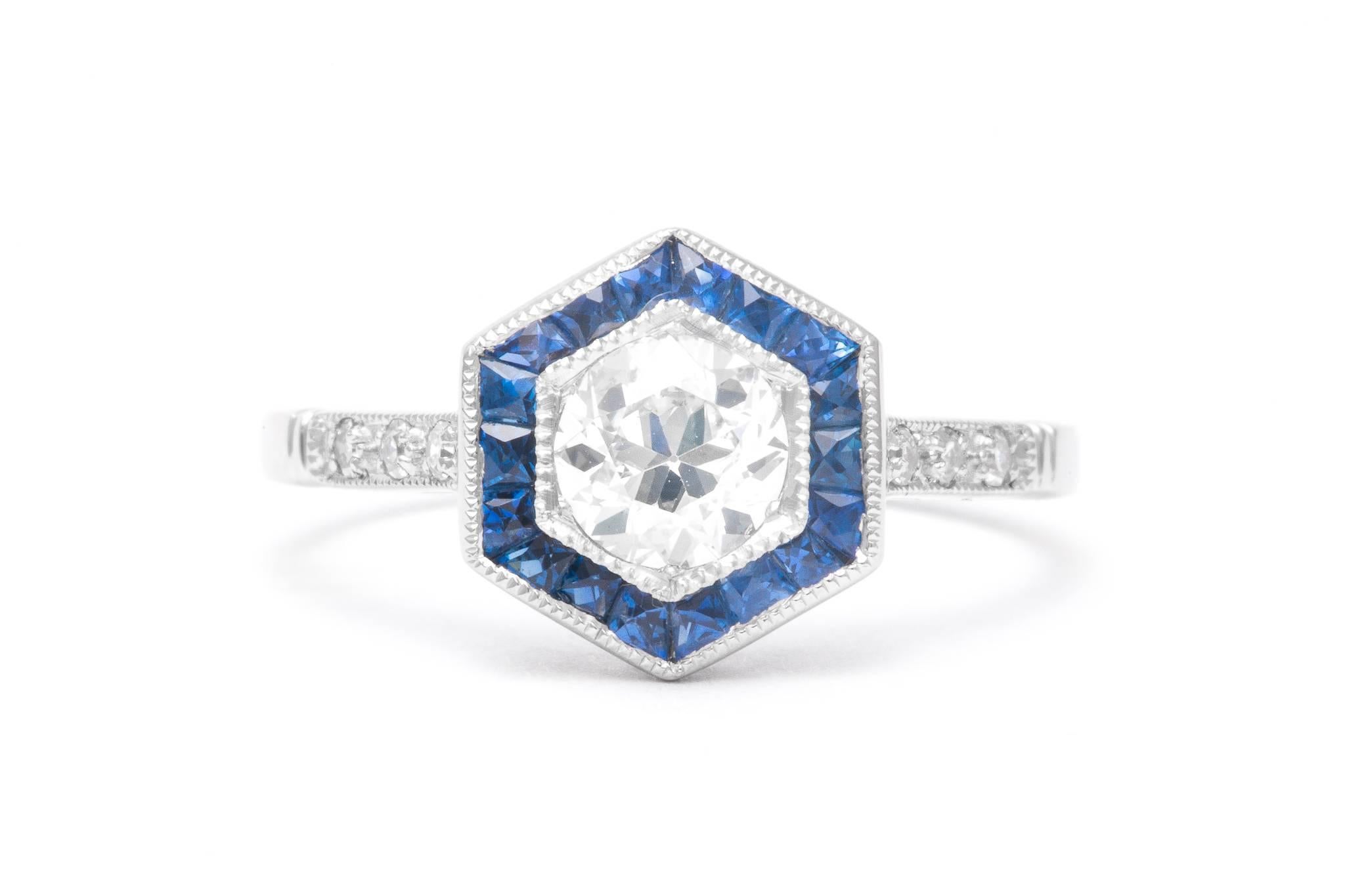 A stunning diamond and sapphire ring in platinum. Centered by a 0.73 carat old European cut diamond this six sided ring features beautiful French cut sapphires surrounding the center diamond in a beautiful platinum mounting.

Grading as VS clarity