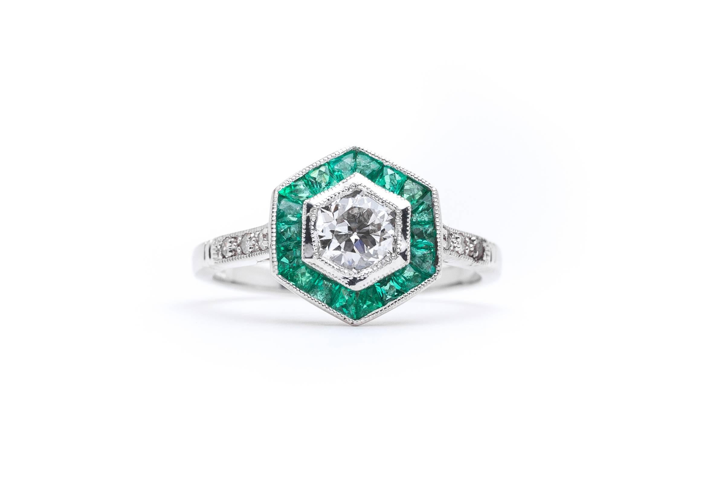 Beacon Hill Jewelers Presents:

A stunning art deco period inspired diamond and emerald ring in platinum. Centered by a 0.73 carat old European cut diamond this six sided ring features beautiful French cut emeralds surrounding the center diamond in