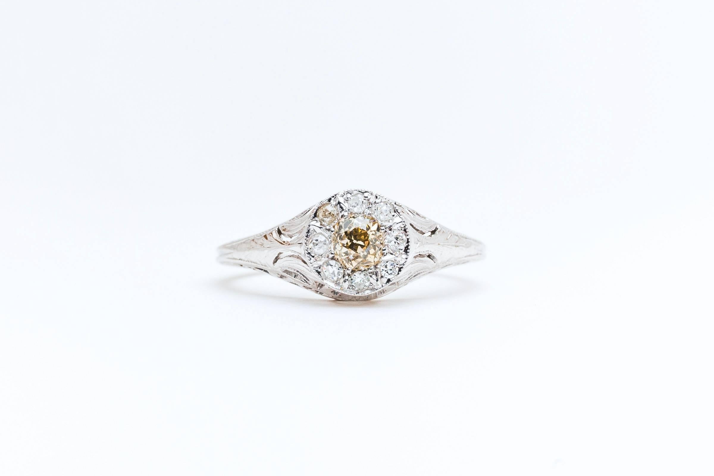 Beacon Hill Jewelers Presents:

An art deco champagne and colorless diamond ring in 18 karat white gold. Centered by a beautiful natural fancy champagne diamond weighing 0.35 carats, this ring features a surrounding halo of eight accenting bright