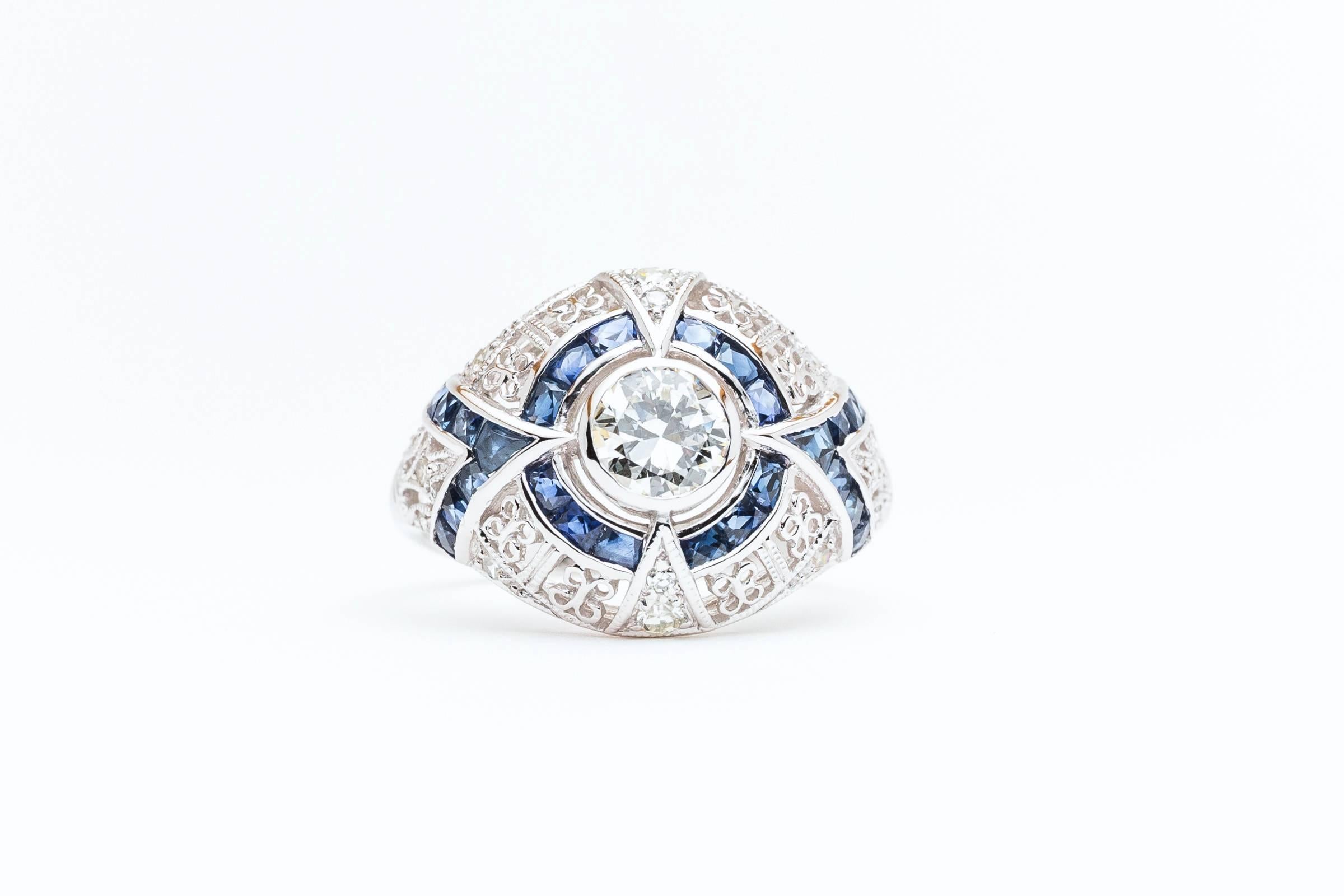 Beacon Hill Jewelers Presents:

A stunning sapphire and diamond engagement ring in 14 karat white gold. Centered by a sparkling antique mine cut diamond of 0.60 carats, this stunning ring is set throughout with hand calibre cut sapphires, and