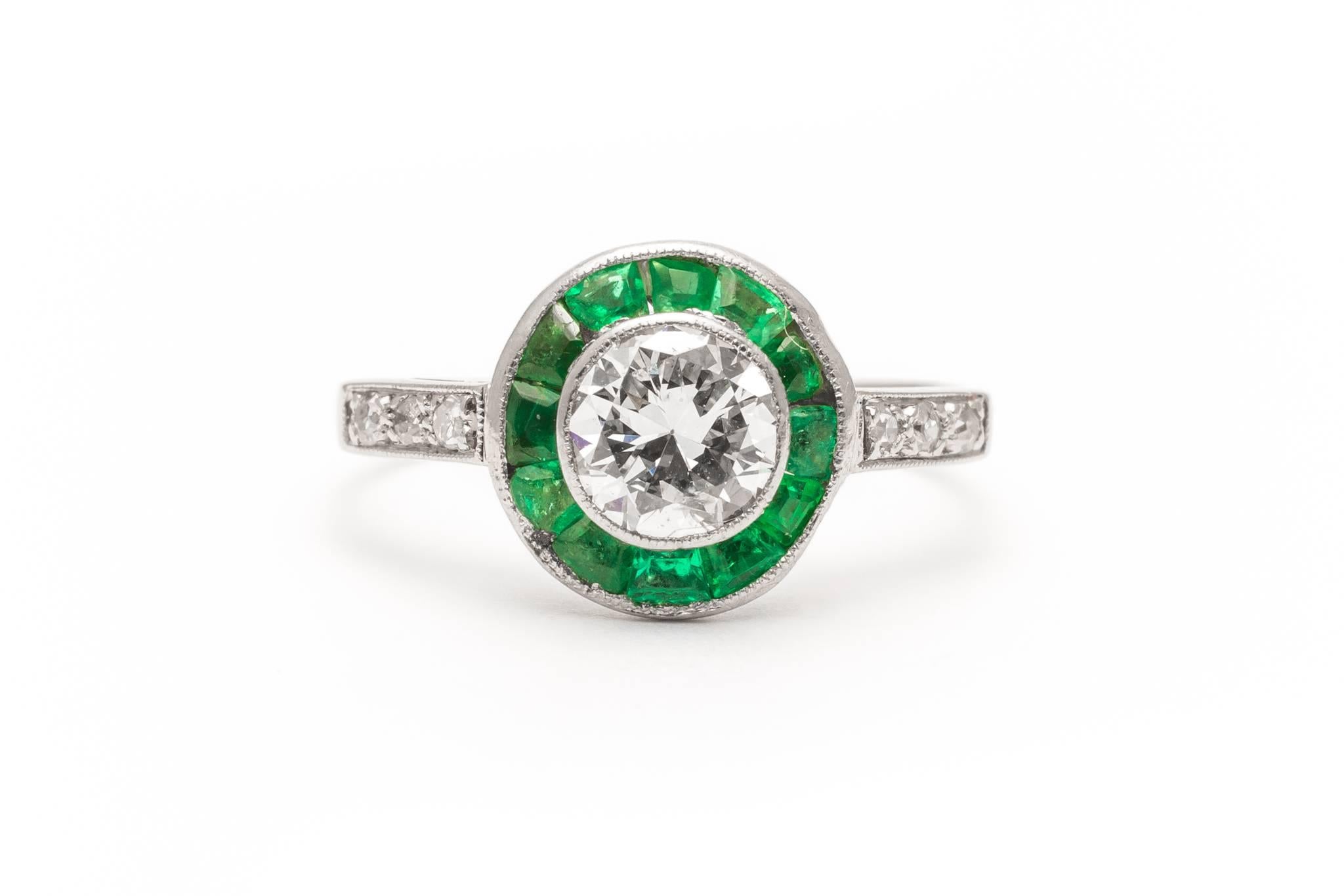 Beacon Hill Jewelers Presents:

An original art deco period diamond and emerald target style ring in luxurious platinum. Handmade in England, this ring features a central 0.80 carat European cut diamond framed by a halo of a dozen natural emeralds