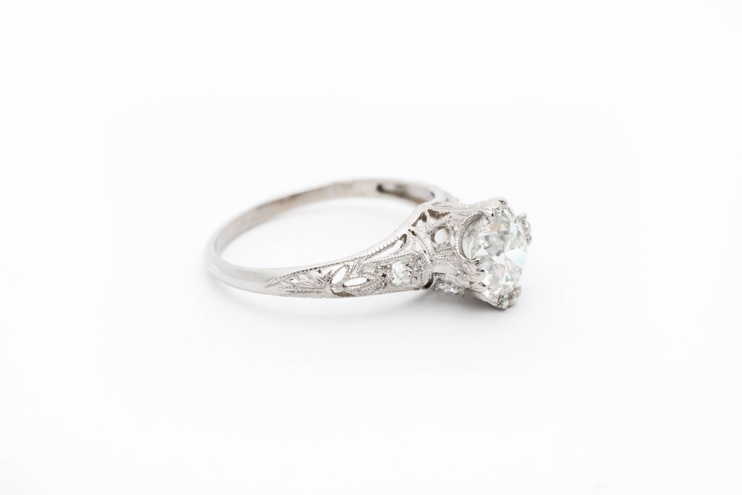 A beautiful handmade art deco period diamond engagement ring in luxurious platinum. Centered by a stunning 1.42 carat old European cut diamond, this ring features fantastic hand pierced filigree work throughout complemented by beautiful hand