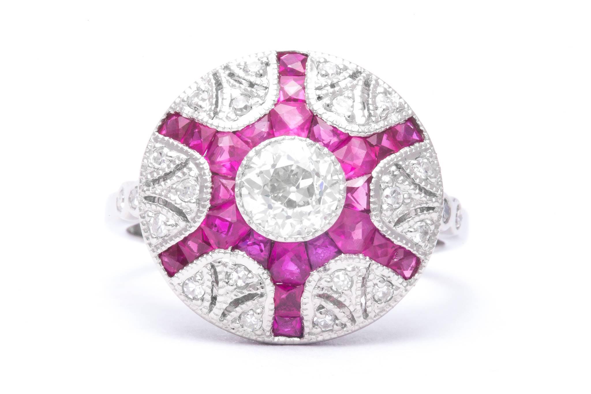 A beautiful ruby and diamond ring in luxurious platinum. Centered by a sparkling old European cut diamond in a mille grained bezel this ring features ravishing rich red French cut rubies and sparkling single cut diamonds in a handcrafted platinum