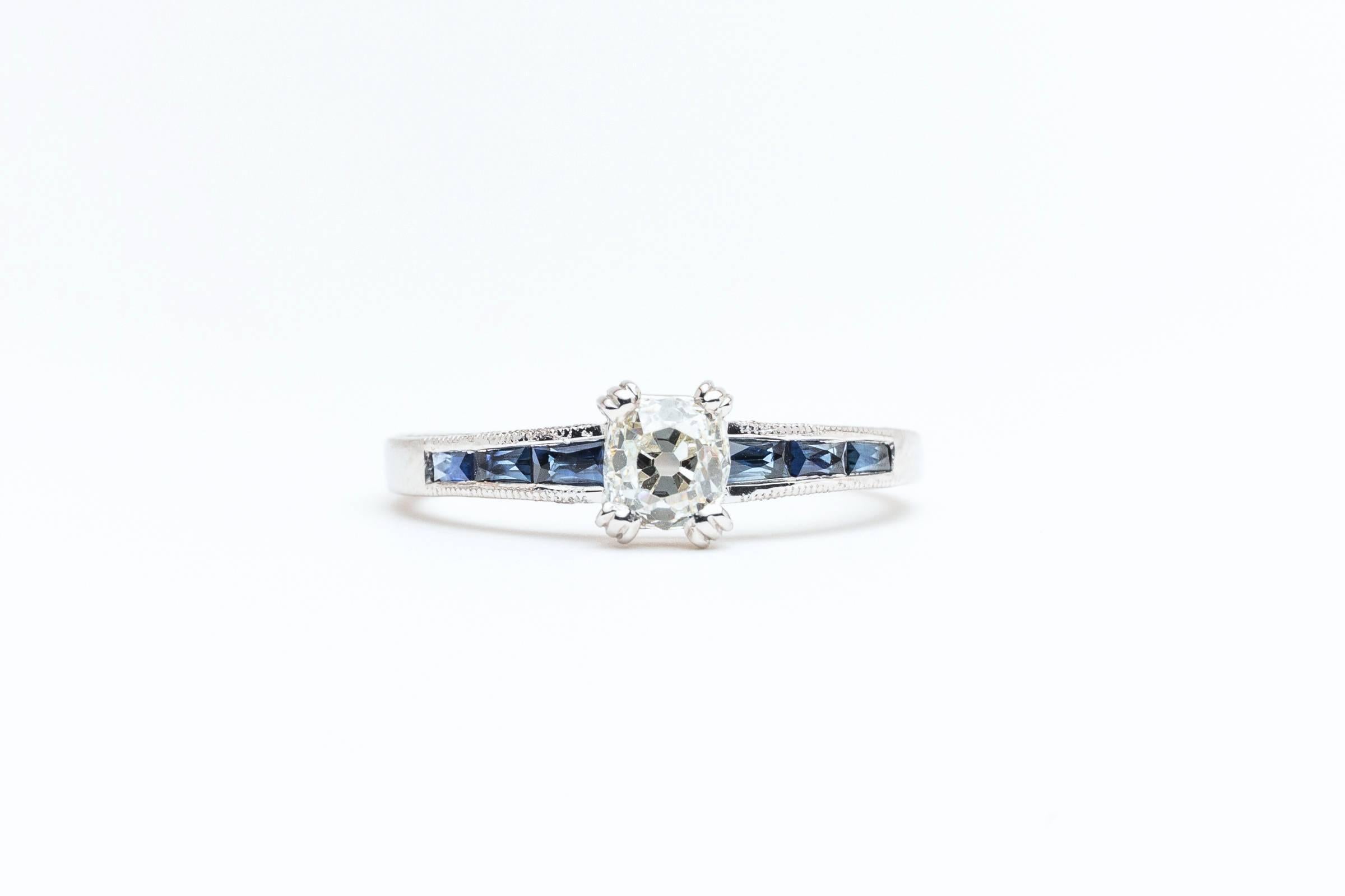 Beacon Hill Jewelers Presents:

A beautiful handmade diamond and sapphire engagement ring in luxurious platinum. Centered by a sparkling antique old mine cut cushion shaped diamond, this ring features channel set French cut sapphires accented by