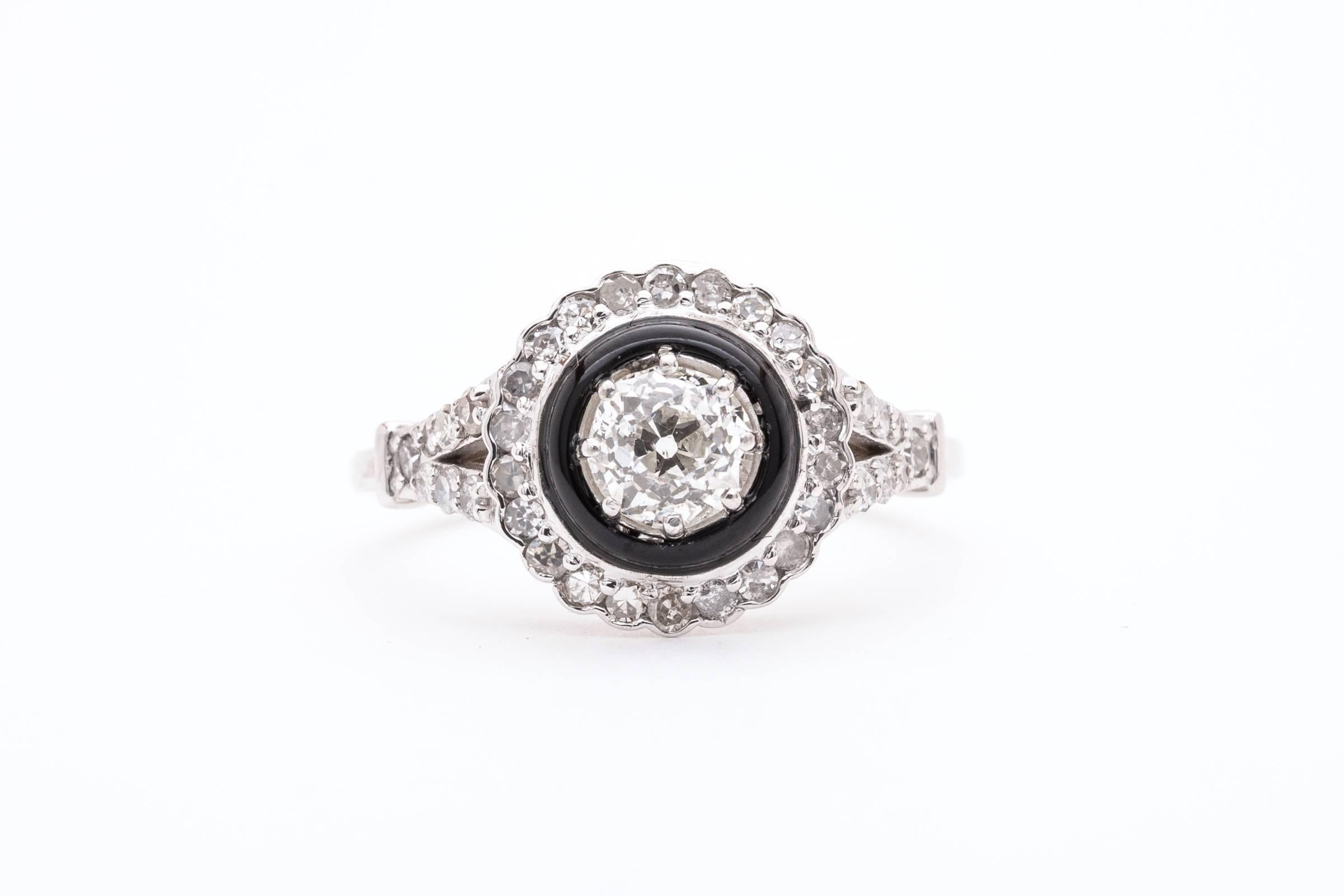 A dramatic diamond engagement ring in 14 karat white gold. Centered by a 0.56 carat European cut diamond this ring features a double halo of pave set diamonds and rich black onyx.

Grading as beautfiul VS clarity and top white G/H color the center