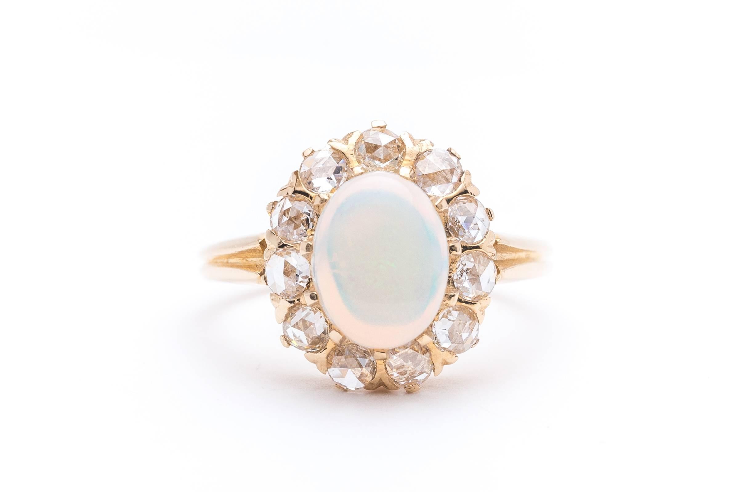 Beacon Hill Jewelers Presents:

A beautiful handmade opal and rose cut diamond ring in 14 karat yellow gold. Beautifully handcrafted, this victorian ring features a beautiful jelly opal surrounded by eleven large rose cut diamonds.

Measuring in