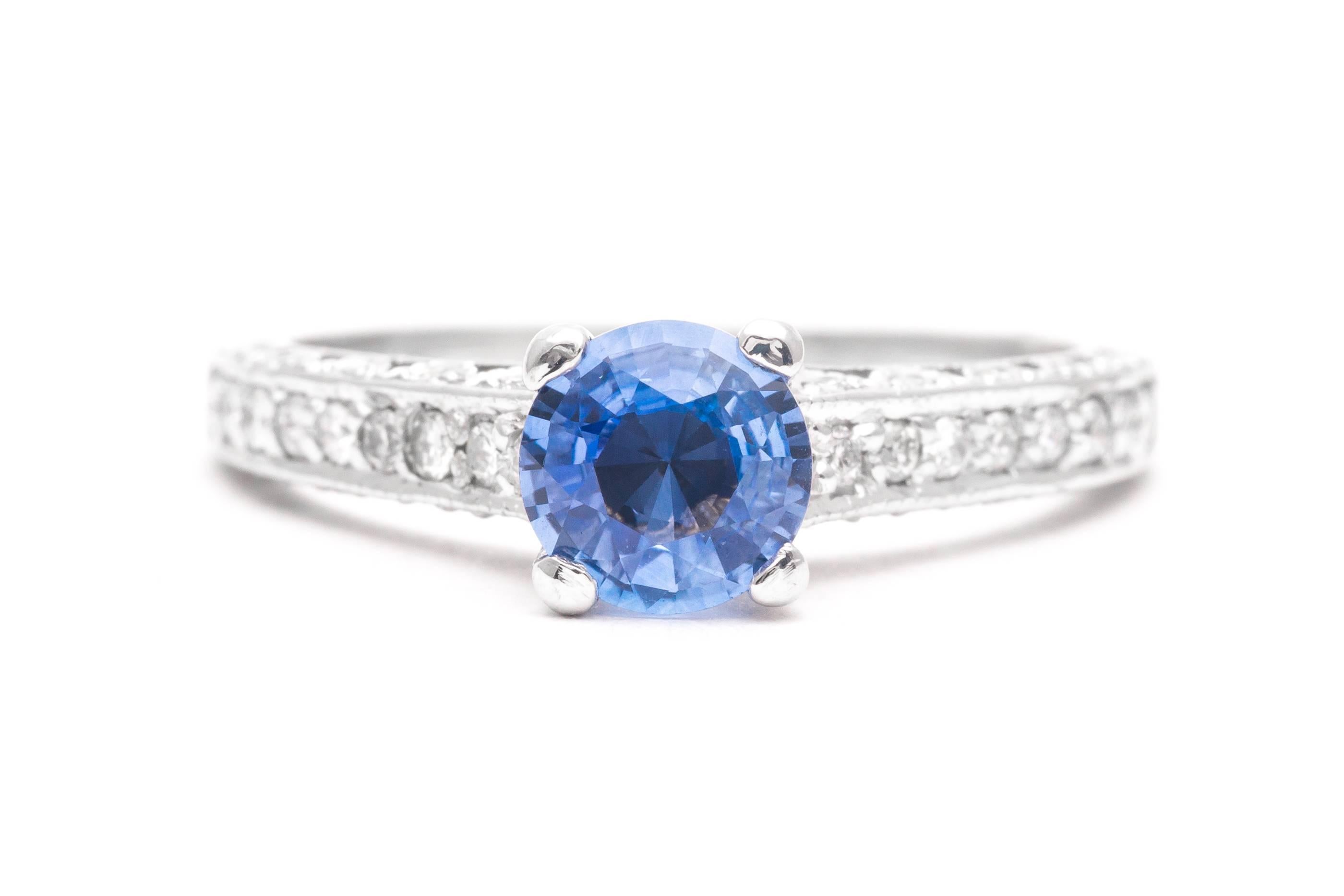 A sparkling sapphire and diamond engagement ring in 14 karat white gold. Center by a top quality natural Ceylon sapphire this ring features a total of forty four accenting diamonds set throughout the mounting.

Grading as superb VS clarity and