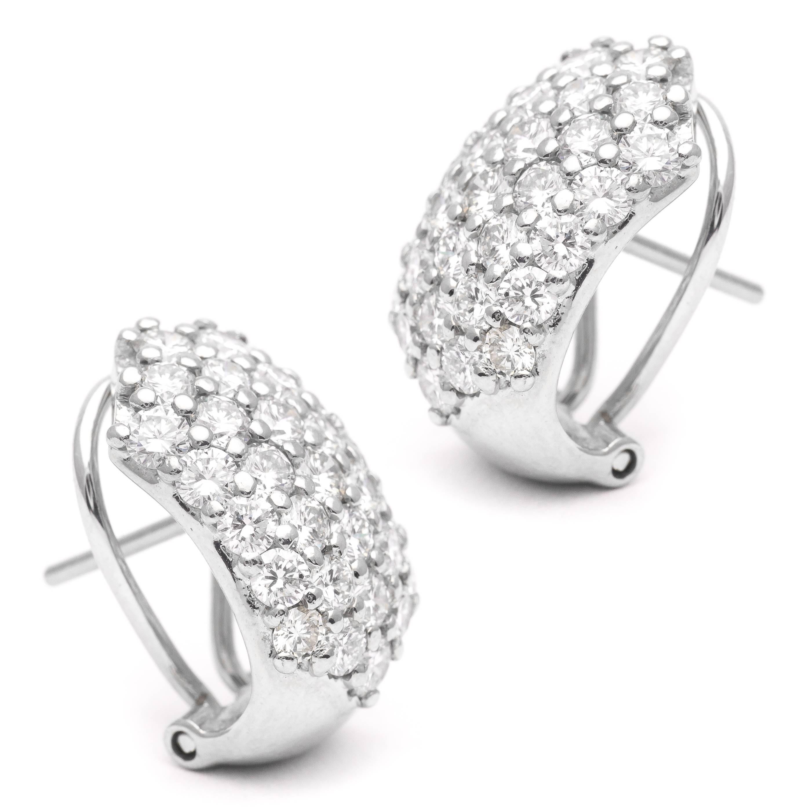 A pair of pave set diamond huggie style earrings in glistening 18 karat white gold.  Set with a total of fifty eight high quality brilliant cut diamonds, these earrings boast a total carat weight of 4.64 carats.

Grading as beautiful VS clarity and