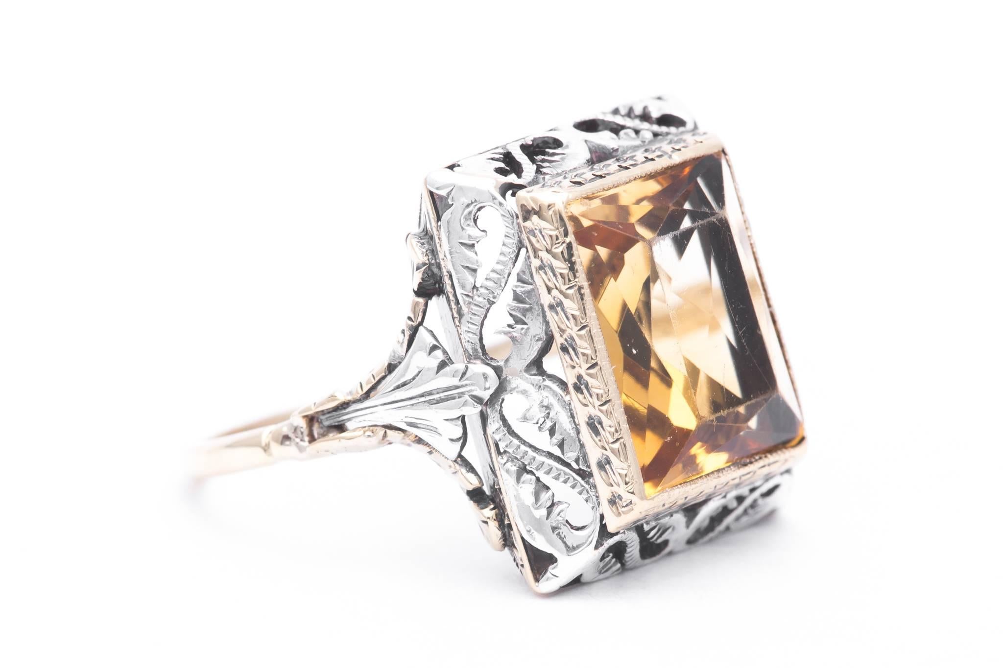 An art deco period citrine filigree ring in yellow gold and silver.  Featuring a rectangular cut citrine this ring features hand carving and hand pierced elaborate filigree work throughout.

Grading as VVS clarity and beautiful golden yellow, the