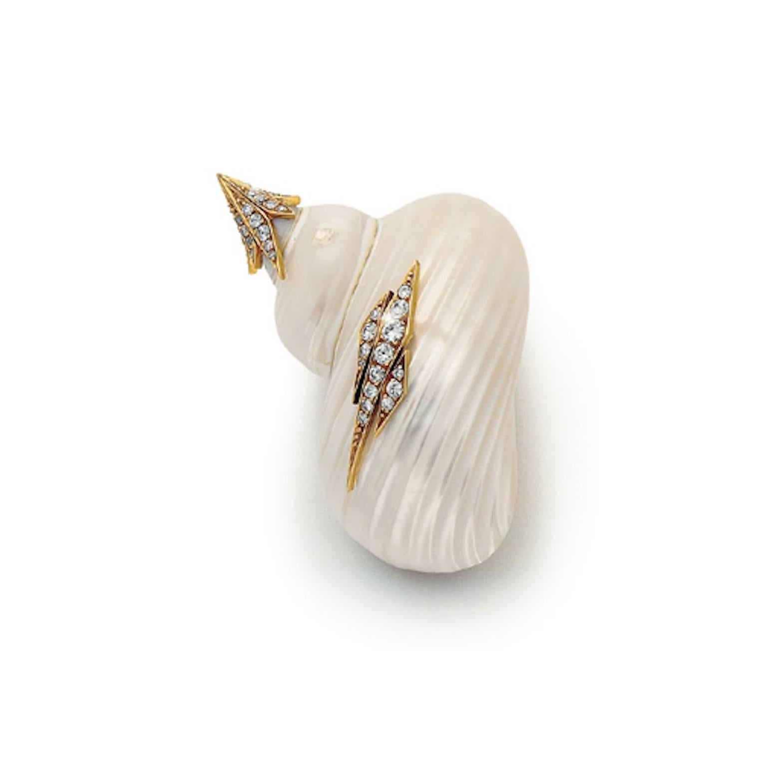 Polished periwinkle shell mounted with 18k gold on the side and point and set with diamonds. It is marked 