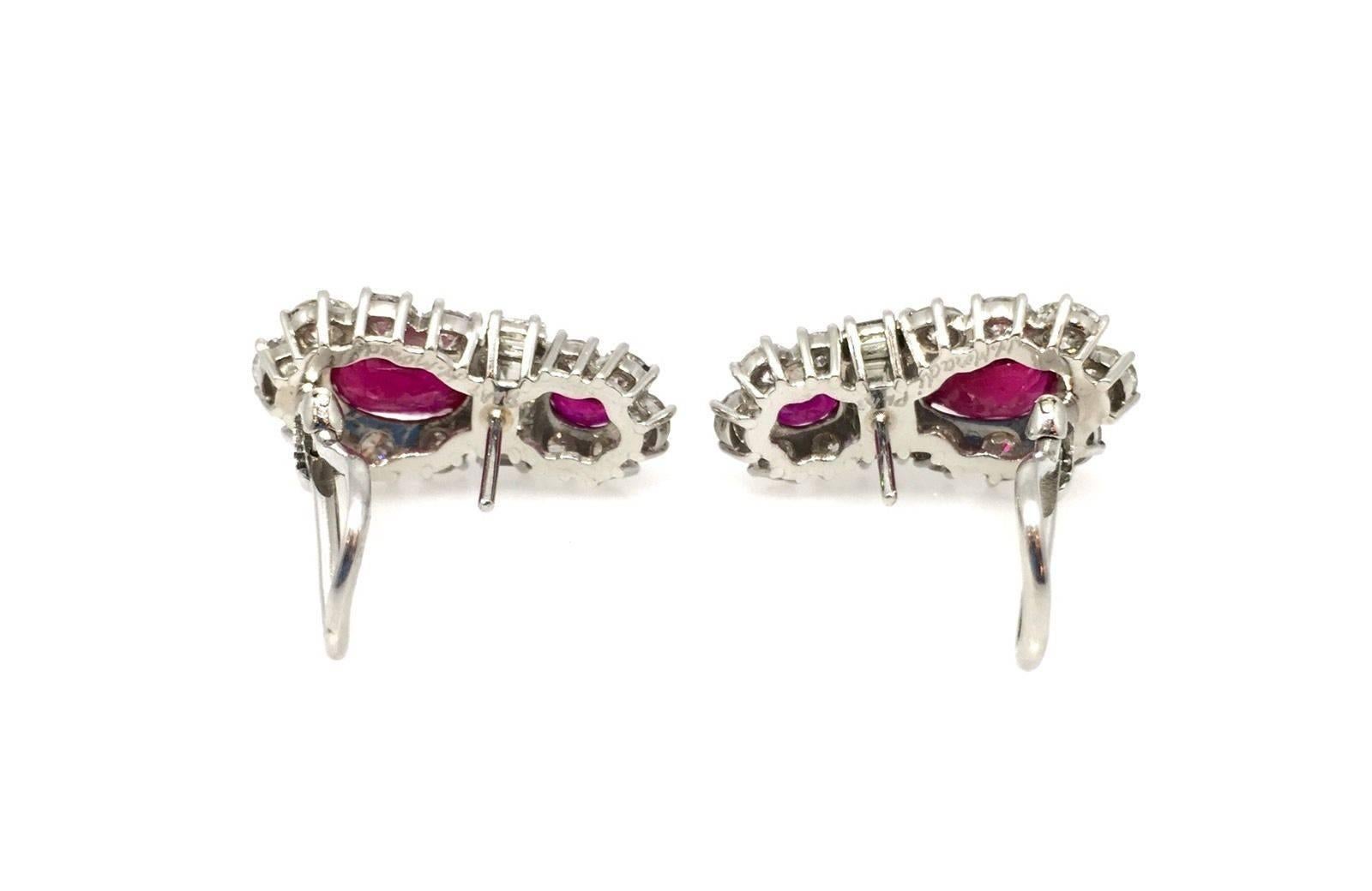 Custom made Ruby and diamond earrings featuring two oval rubies with GIA certificate 2.14 ct and 2.18 ct in size.

There are 24 round brilliant diamonds and 6 emerald cut diamonds totaling 2.54 ct, VS-SI clarity, H-I color.  

Two smaller oval