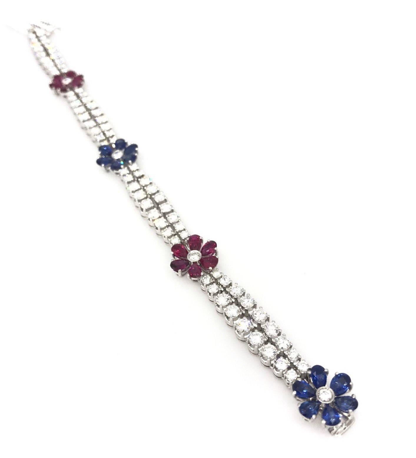Diamond, Ruby and Sapphire bracelet in 18k white gold featuring double row of round brilliant diamonds separated by Ruby and Sapphire florets, 8.00 ct total diamond weight. Diamond quality graded as VS2 in clarity, H in color.

12 Pearshaped Rubies