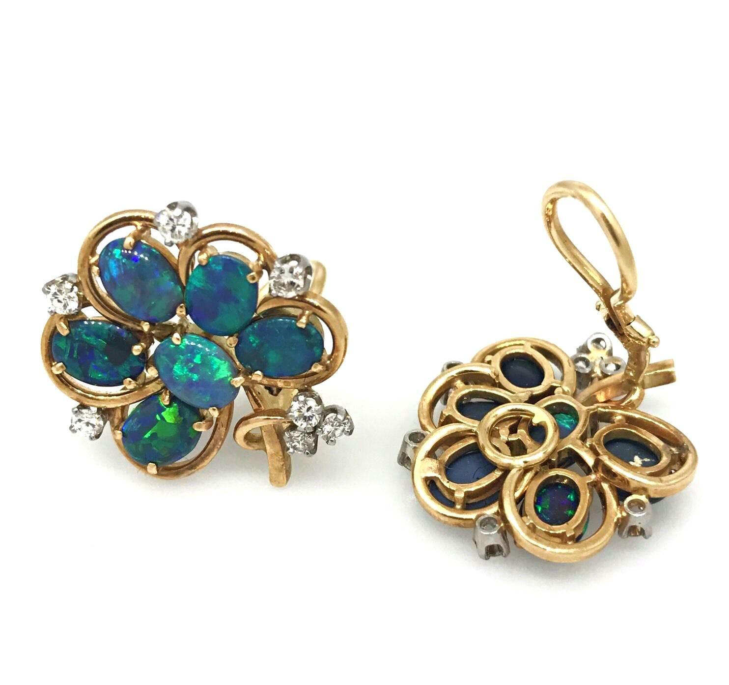 Vintage black Opal flower earrings in 14k yellow and white Gold featuring 12 oval black Opals with green and blue flashes, set with round brilliant diamonds, totaling .56 carats, SI1 clarity, H color. Fastenings are omega backs without posts.