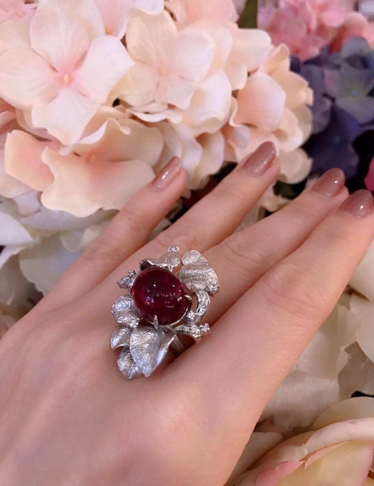 Beautifully detailed Pink Tourmaline and Diamond Ring in Platinum. Center Pink Tourmaline is Cabochon Oval weighing 10.01 carats, set horizontally, surrounded by textured Platinum leaves and a scattering of round brilliant diamonds totaling .25