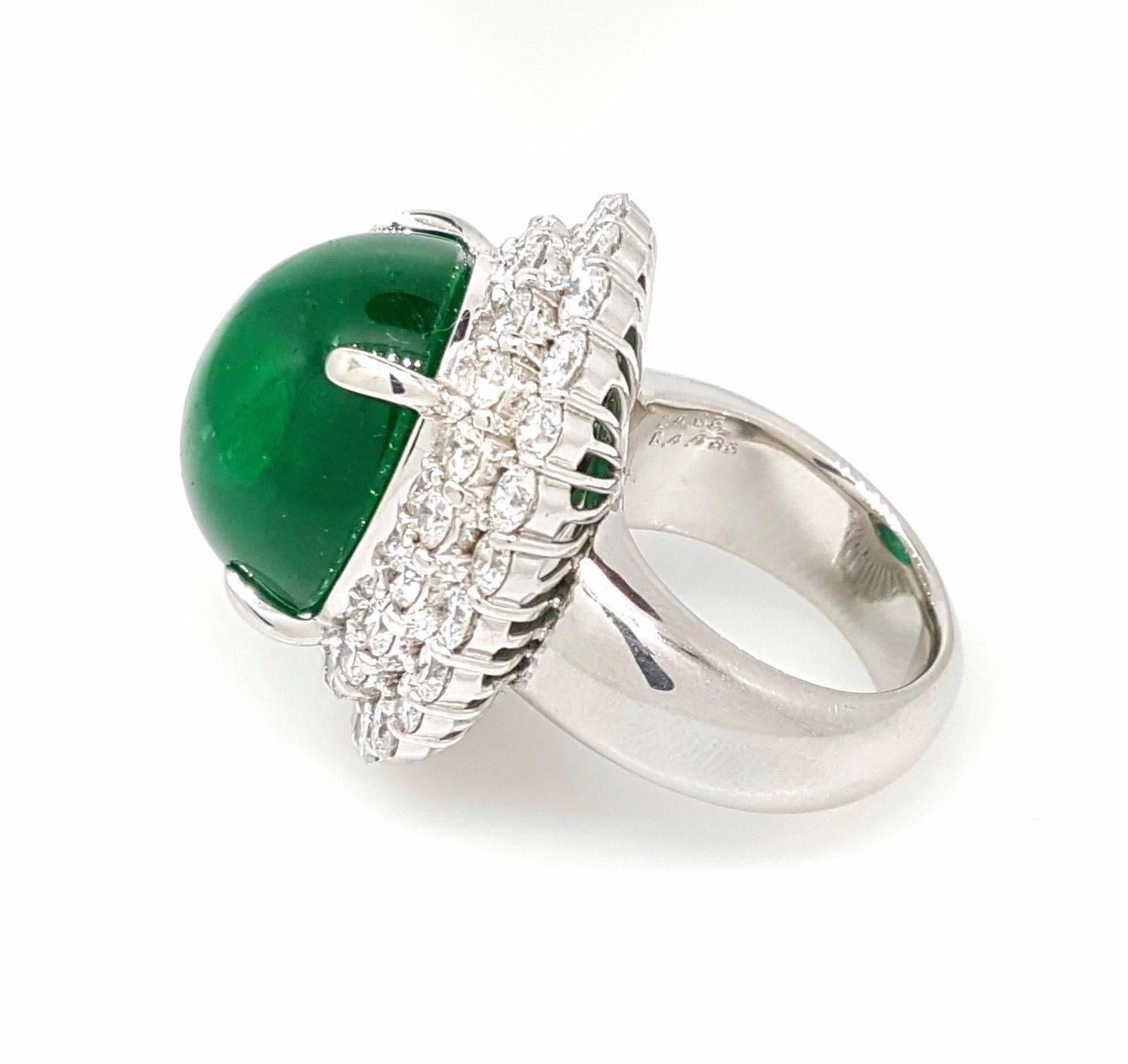 Large emerald cabochon surrounded by two rows of round brilliant diamonds in platinum. Emerald cabochon weighs 24.35 carats and is oval shaped with a deep green color. The piece contains 45 round brilliant diamonds, weighing 4.43 carats. The clarity