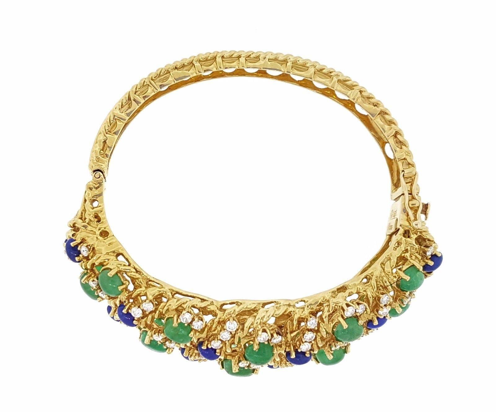 Vintage wide multicolor bangle bracelet with diamonds, emerald and lapis in 18k Yellow Gold. This 58.9 gram bracelet is composed of 67 round brilliant full cut diamonds totaling an estimated 2.00 ct, with bright and lively stones. 
The clarity is