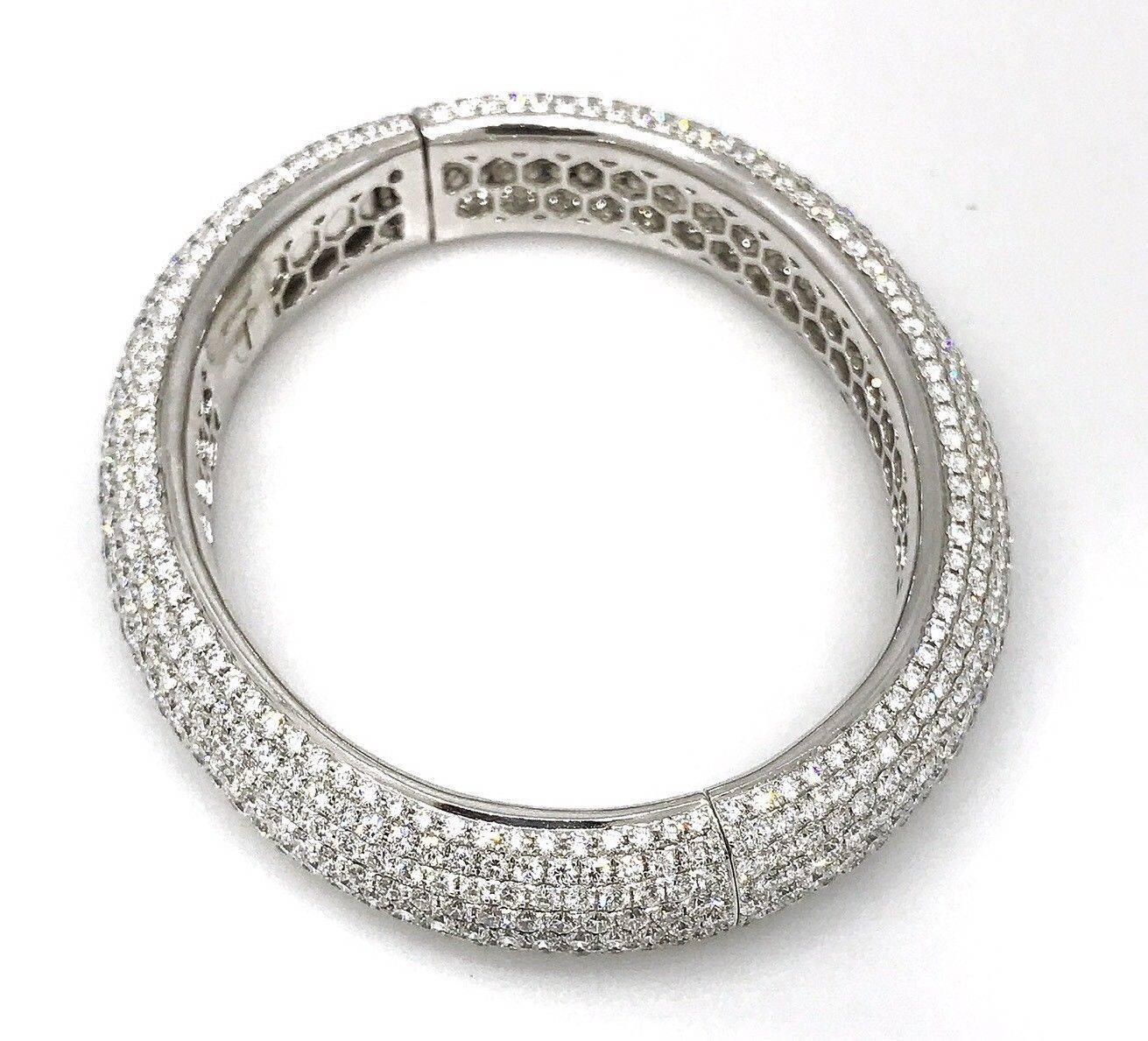 Fine quality, Oval shaped wide band bangle bracelet featuring 
24.29 carats of round full cut diamonds, pave set around entire bangle. Diamond quality of G color and VS clarity, set in 18k high-polished white gold. Easy twisted hinged opening.