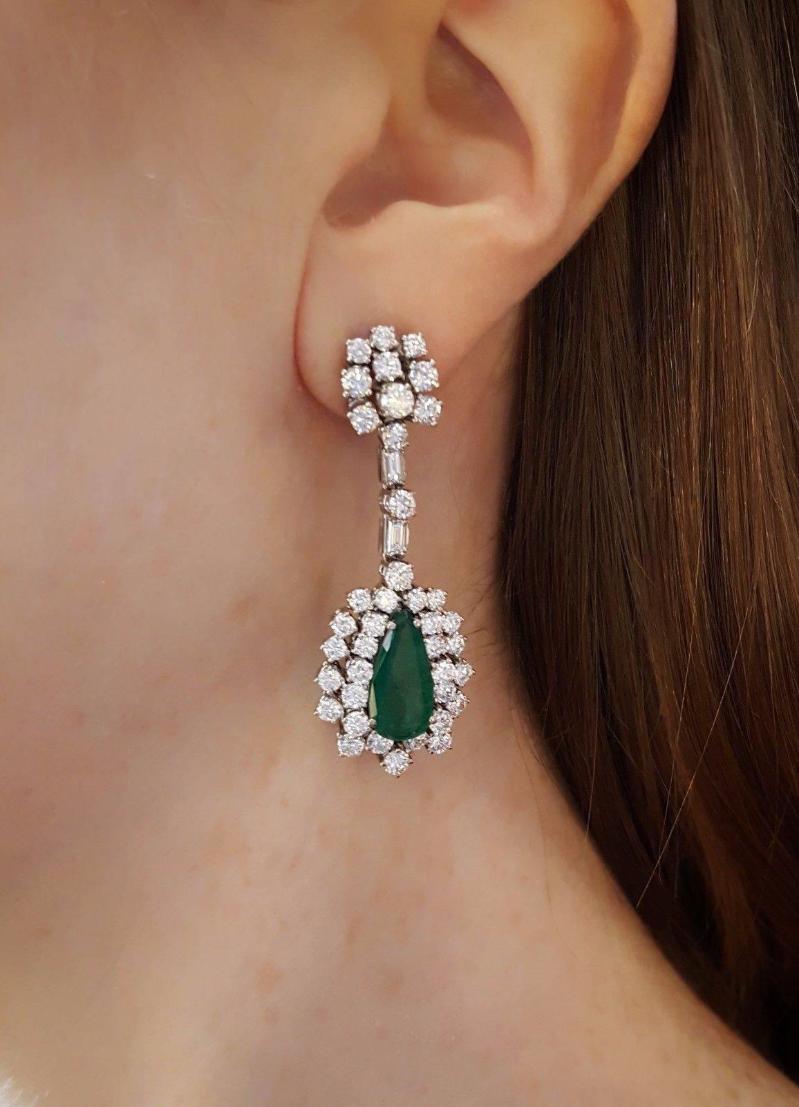 Estate  Emerald & diamond drop earrings featuring two (2) Pear Shaped Emeralds, with lively medium to deep green color weighing approx total Weight of 4.00 carats.  Side stones consist of round brilliant cut diamonds and baguette diamonds,