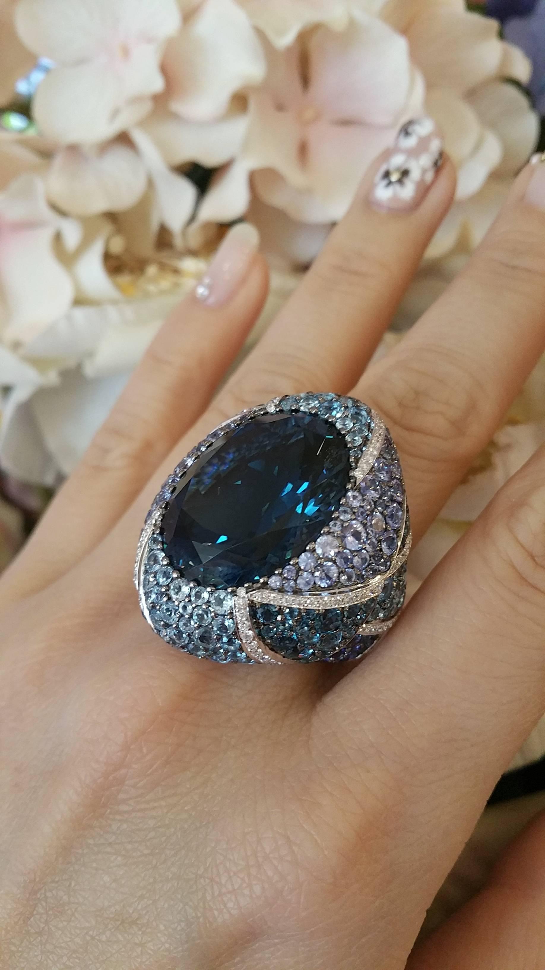 Large Dome Ring with Oval Blue Topaz in the center, surrounded by light and dark shades of Sapphires and Blue topaz stones, pave set over most of the ring. Wonderful play of colors, separated by lines of diamonds.

Blue Topaz weight is 40.49