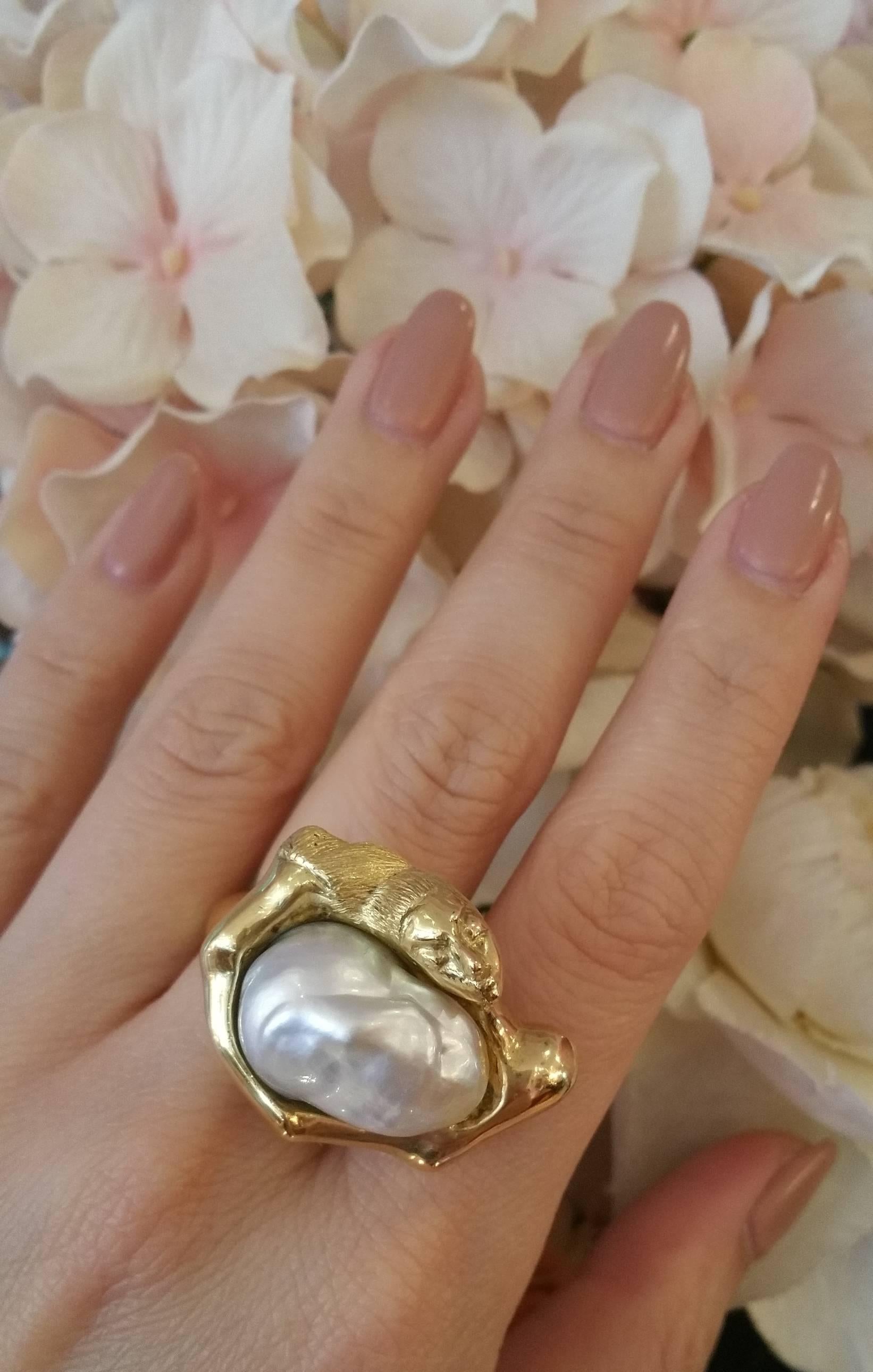 Large and unusual, handsculpted ring with Baroque Pearl measuring 16.5mm, set in high polish, heavy 18k Yellow Gold.  Freeform bezel in the shape of a Woman's head and torso. Fashioned from one piece of metal, shank measures 6.7 mm. Ring sits .75