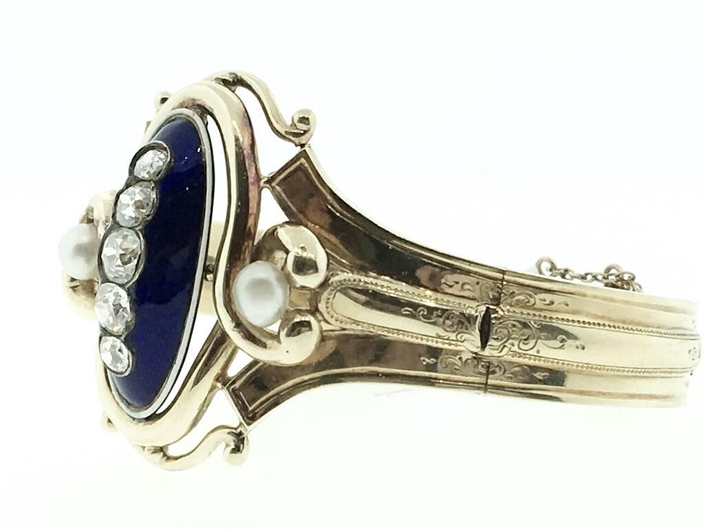 Beautiful French Victorian Hinged Gold Bracelet with center Oval Dome with Five Old Mine Cut Diamonds graduating in size. Centered in Blue Enamel and flanked by two white pearls.  Beautiful engraving where each hinged section meets. Tongue clasp has