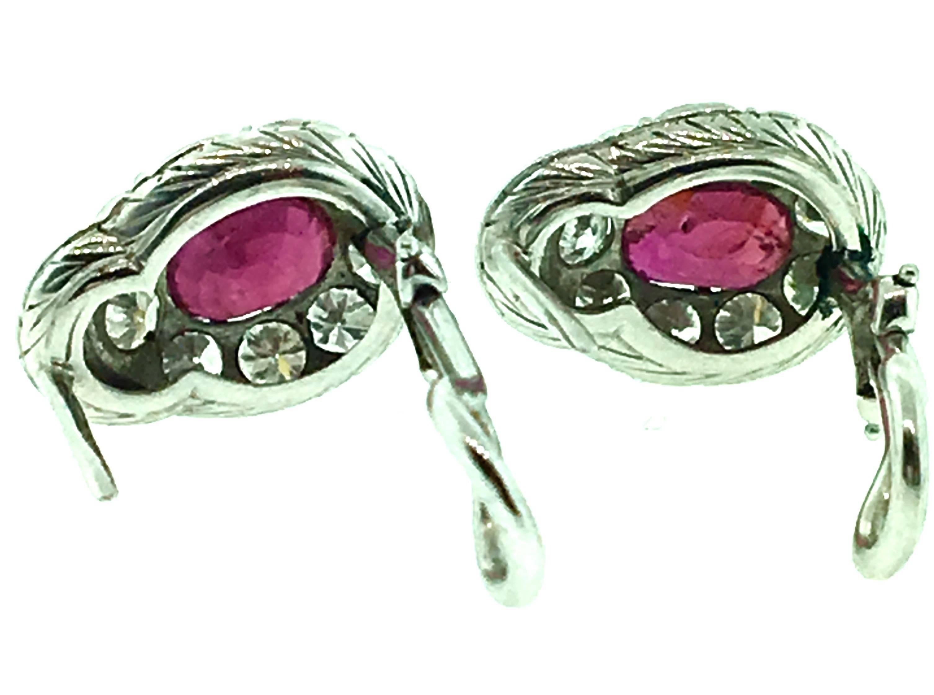 Oval Ruby Earrings surrounded with Round Diamonds set in Platinum.  Nine diamonds circle each Ruby and are topped with 5 single cut Diamonds. Earrings contain estimated 1.00 ct in Red Oval Rubies and 1.60 ct estimated in Round Diamonds. Diamond