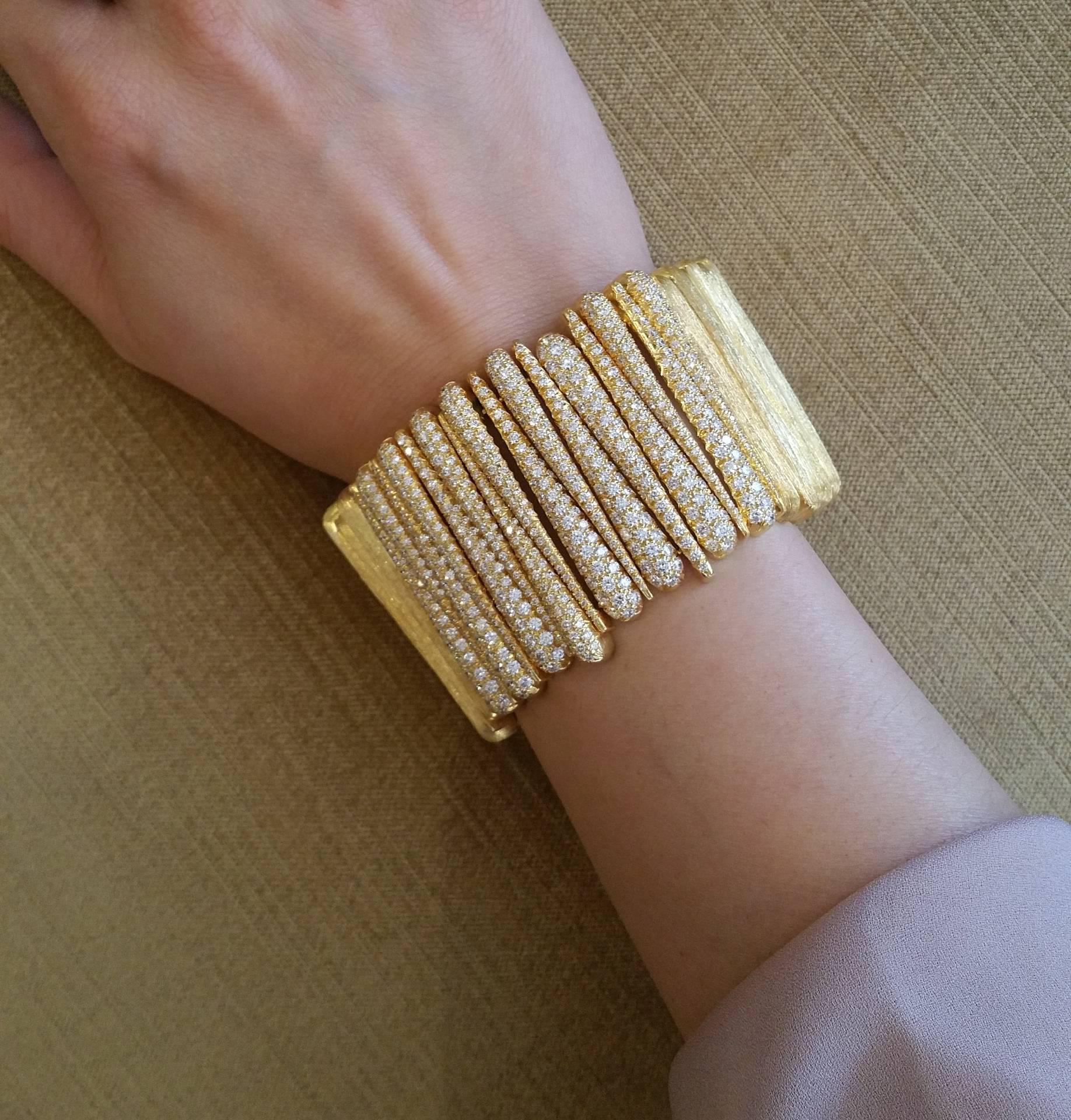 Exquisite Henry Dunay gold and Diamond 'Sabi' wide flexible bracelet featuring alternating series of tapered brushed 18k gold links.  Centering is over 15 cts approx. of round brilliant diamonds.  Fits up to 7