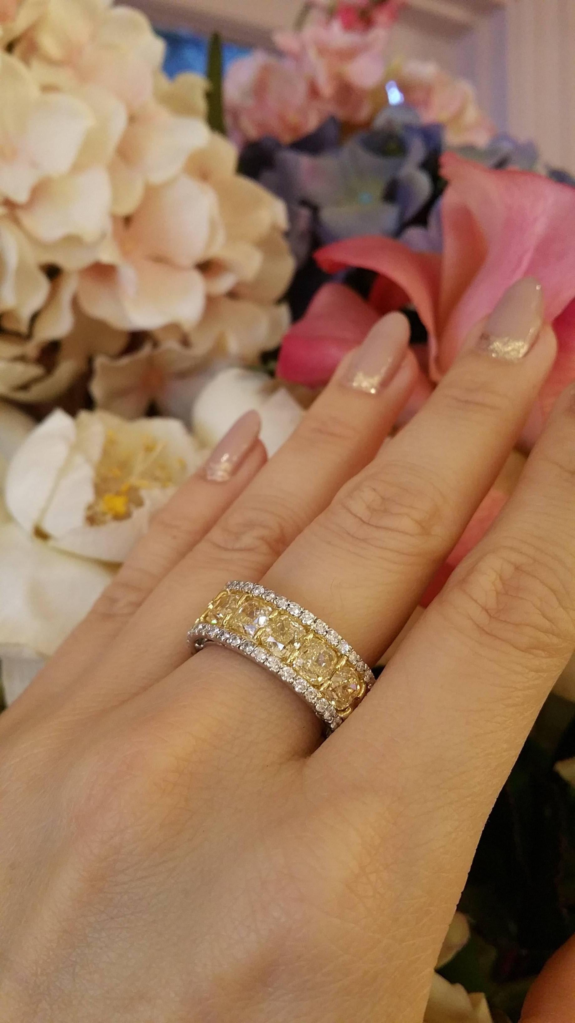 Eternity band featuring 15 beautiful cushion brilliant Yellow diamonds along the center weighing a total of 10.70 cts., and 80 white round brilliant cut diamonds along the edge weighing 1.68 ct. All high quality diamonds with approx VS in clarity.
